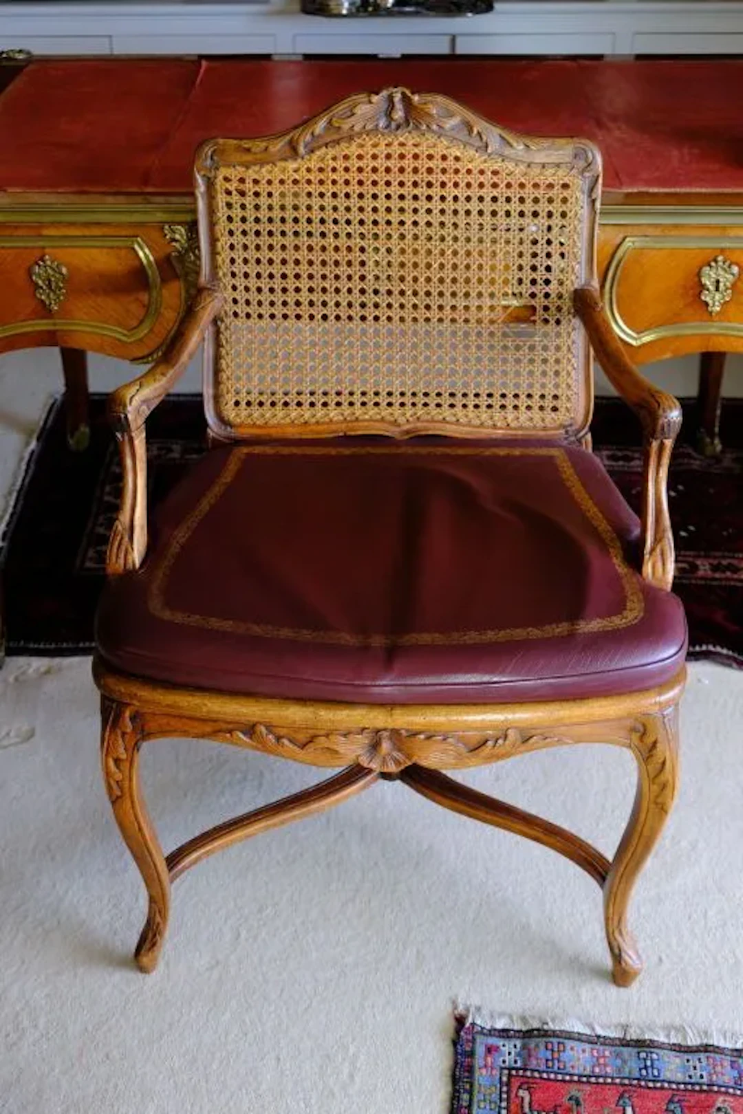 Natural wood cane armchair, carved with acanthus leaves; the curved