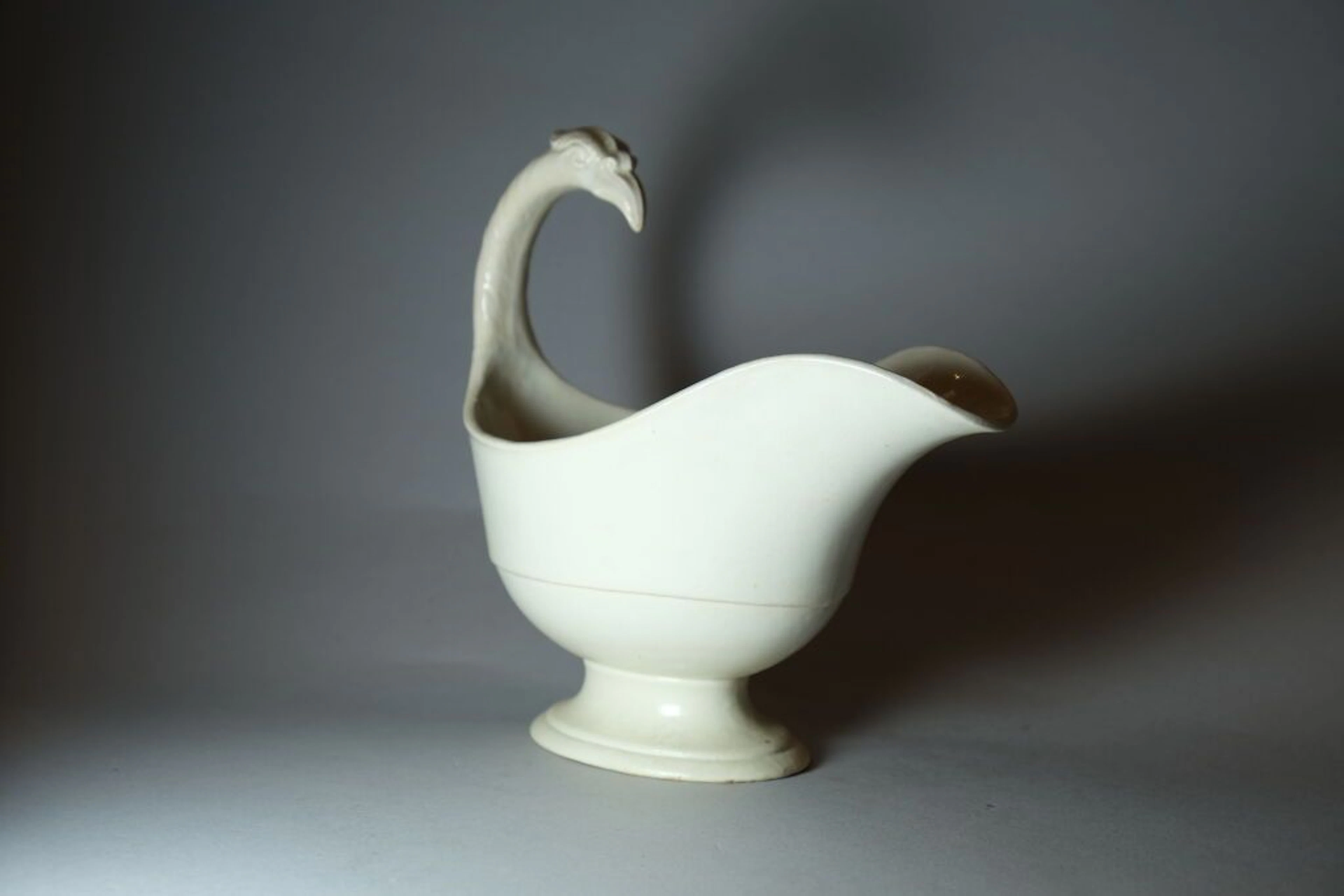 Glazed stoneware sauce boat with a helmet-shaped handle featuring