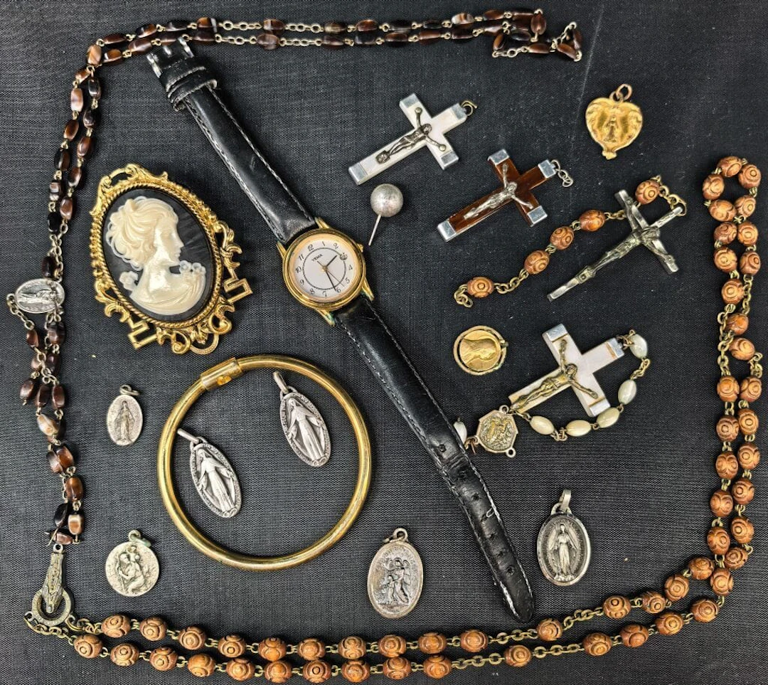 A set of costume jewelry, including medallions, crucifixes, a Yema