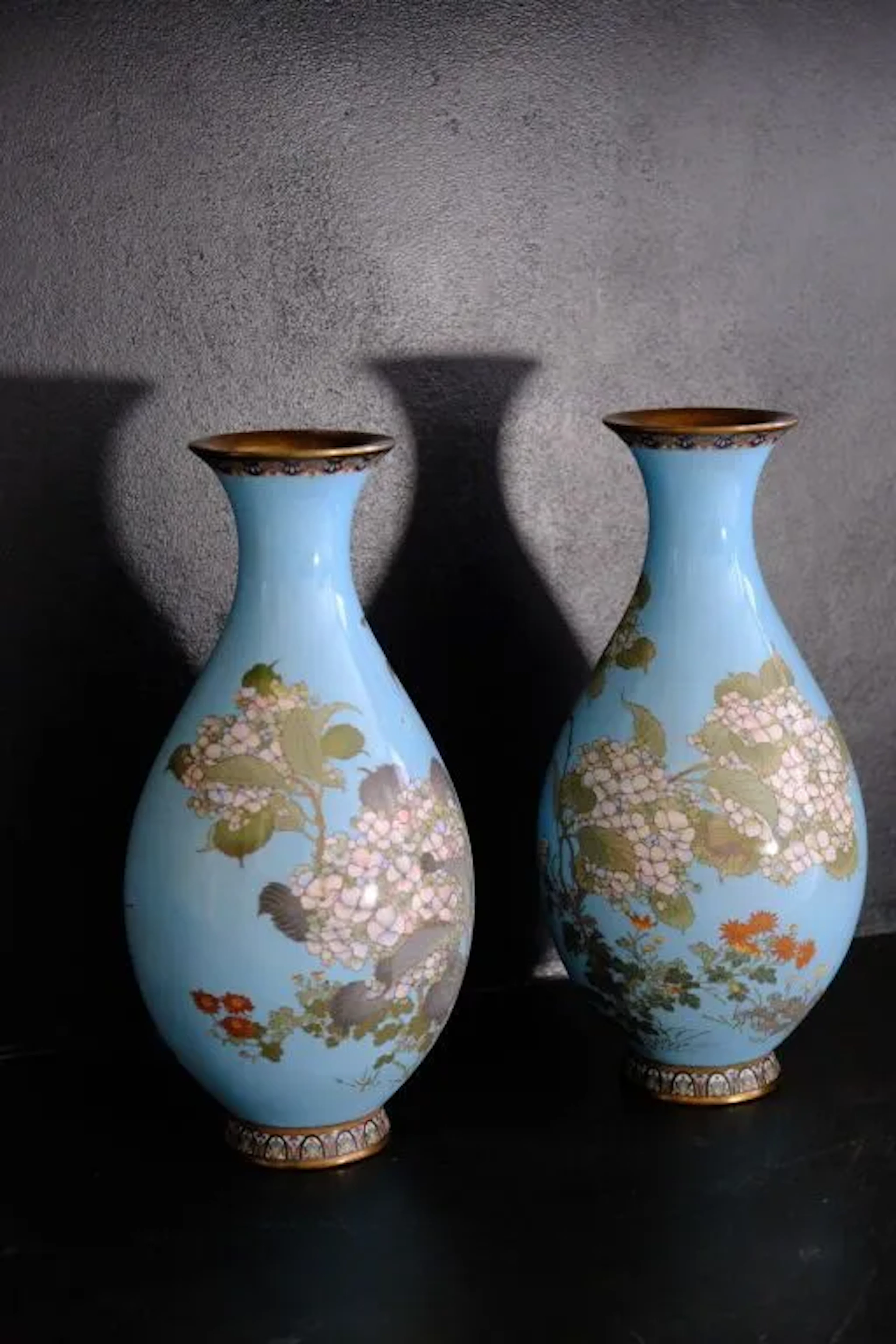 Pair of enameled vases with a light blue background and polychrome