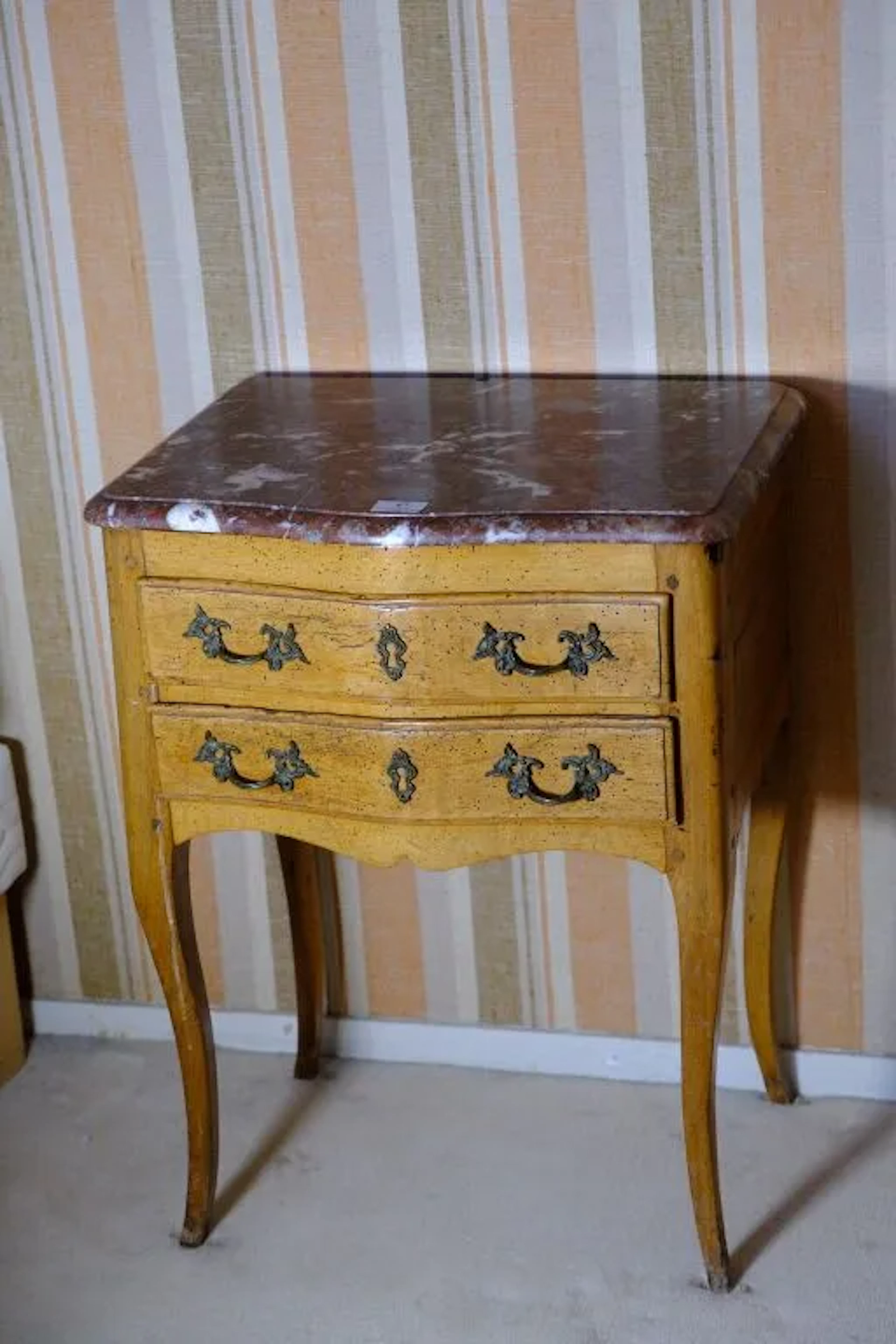 Natural wood nightstand with two side-mounted drawers. Top in cherry-red