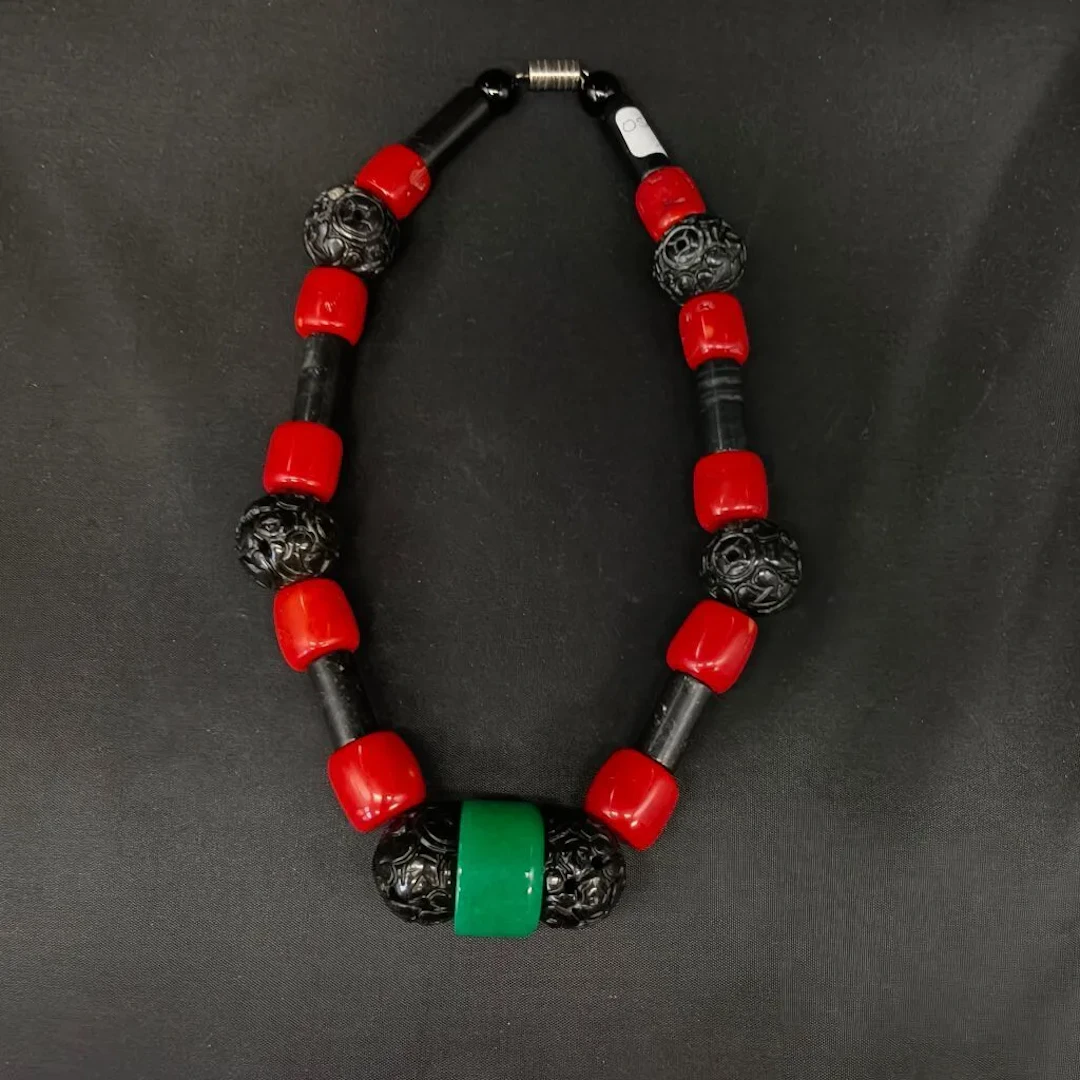 A large necklace made of beads and sections of multicolored materials.
