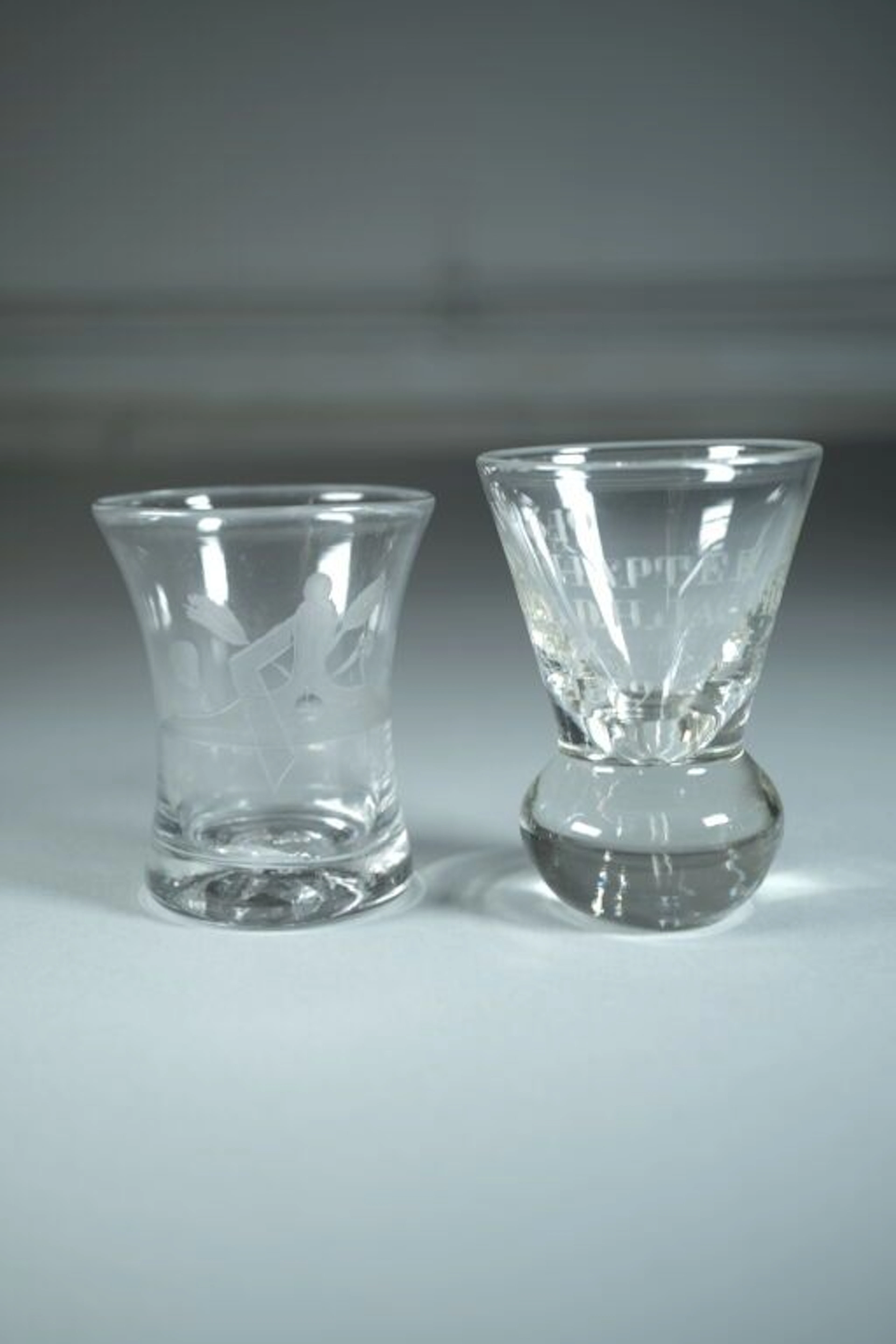 A set of two cut crystal glasses consisting of: - The first is engraved