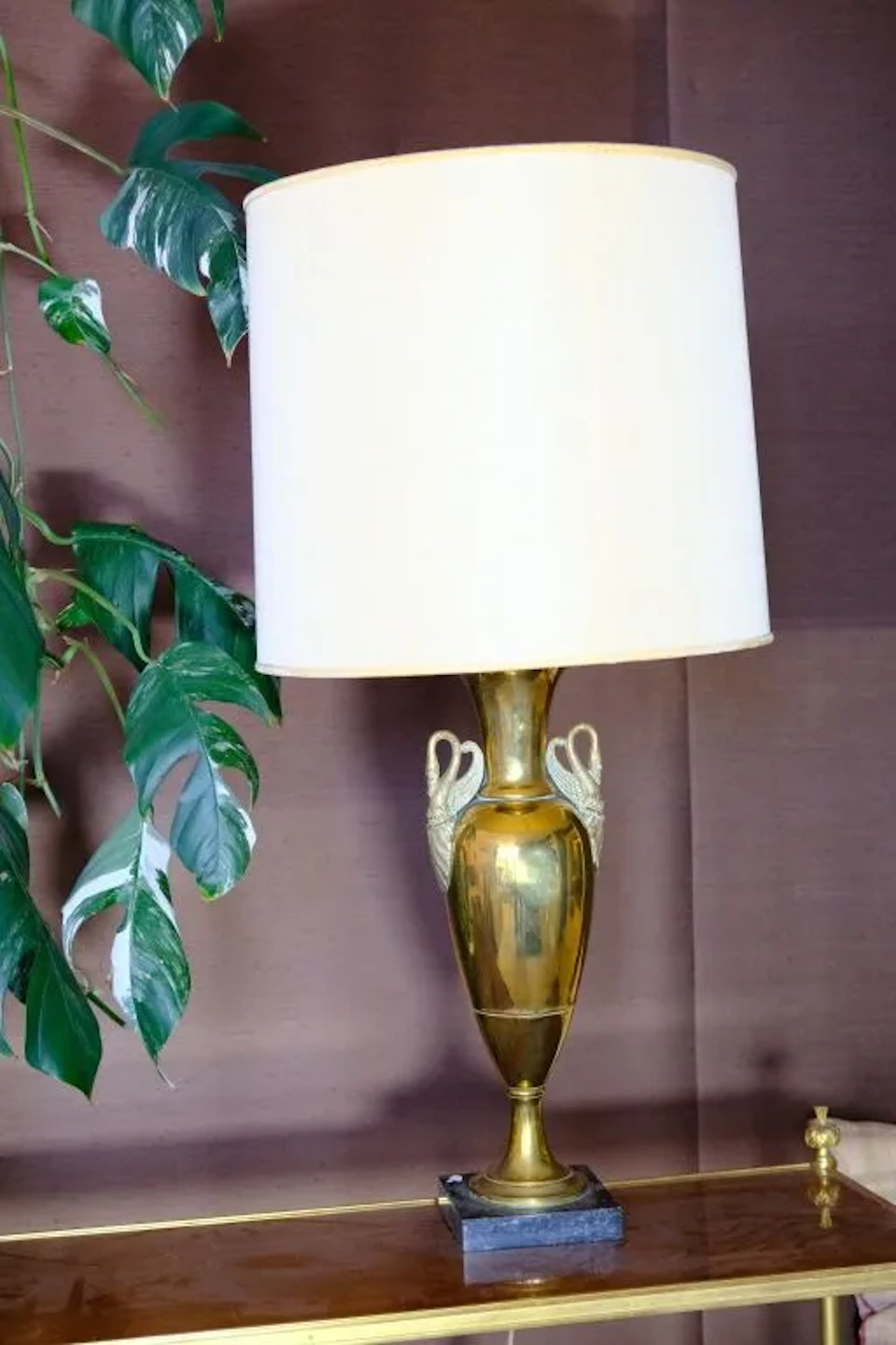 Copper urn-shaped living room lamp with swan-neck handles resting