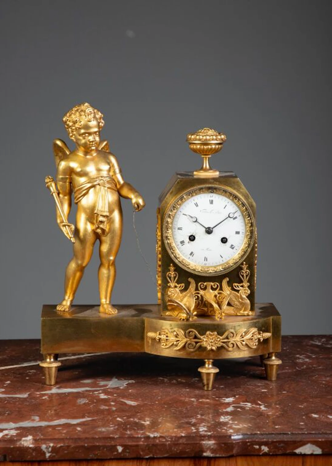 Chiseled and gilded bronze table clock featuring a decoration of a