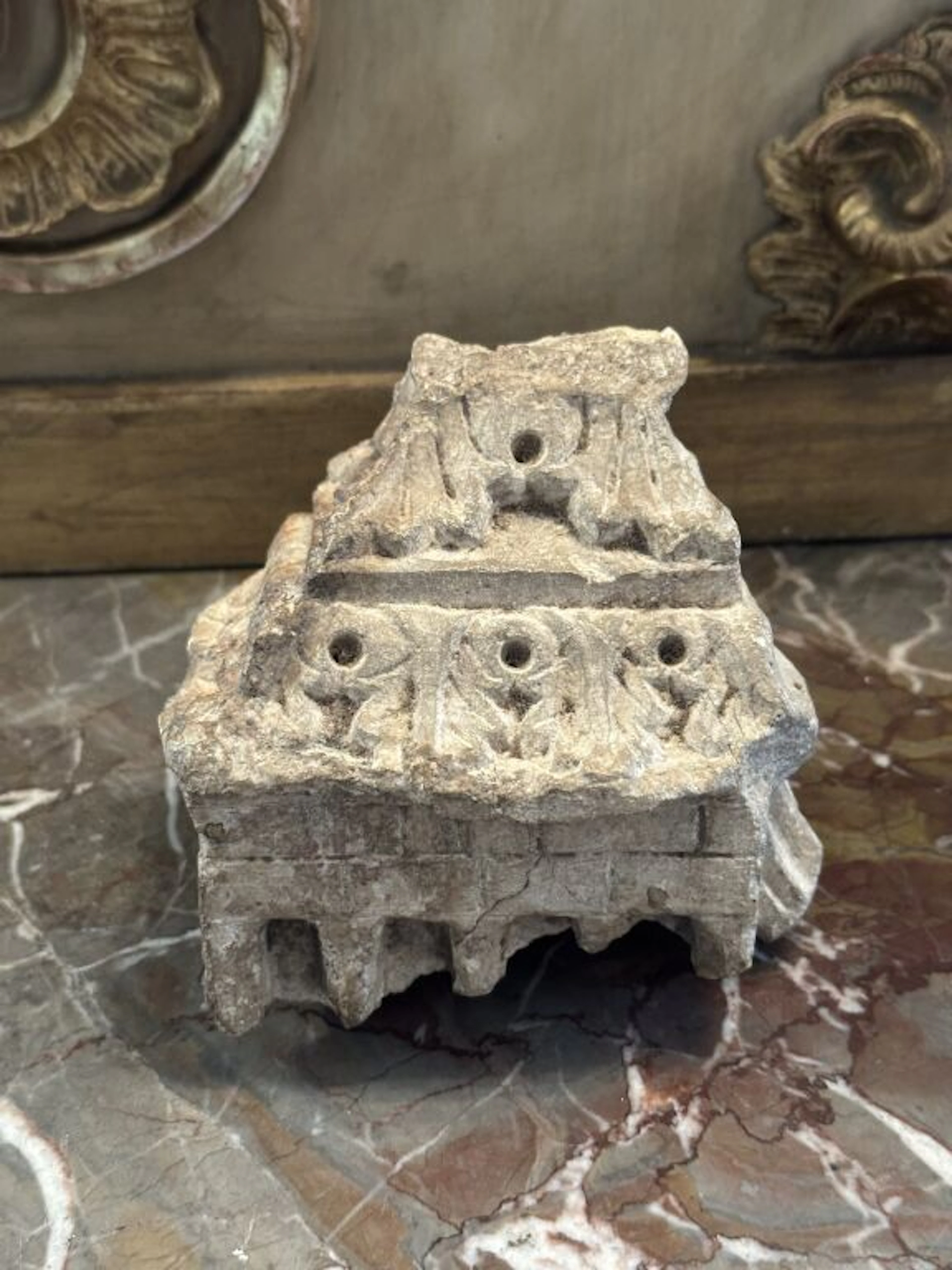 An architectural element carved from stone, decorated with upright