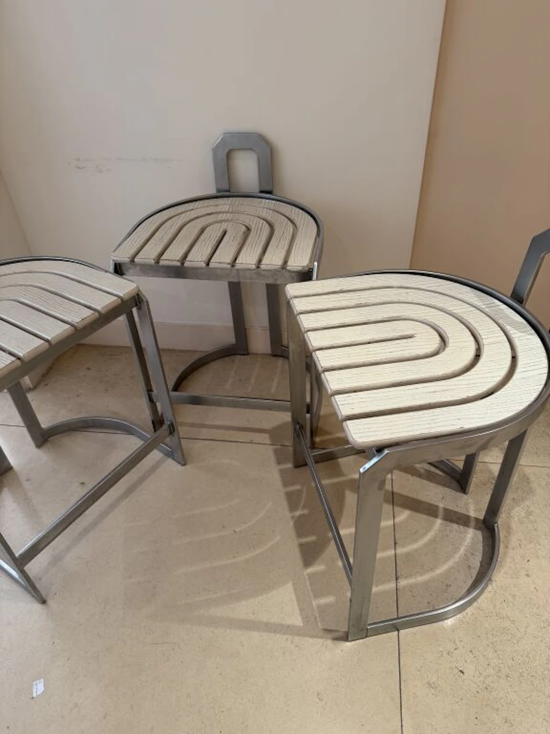 Set of three Art Deco-inspired bar stools in stainless steel and white