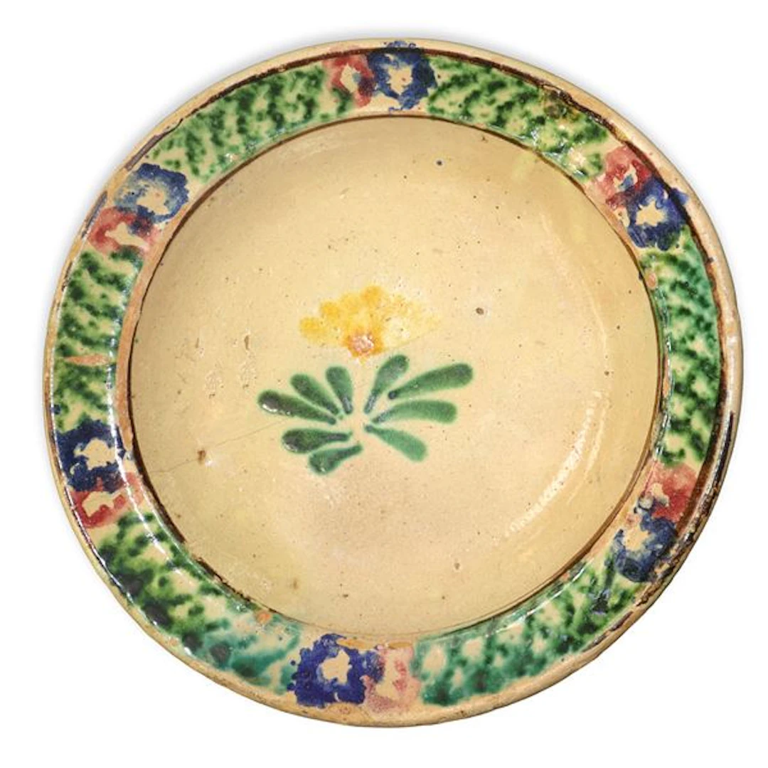 Piatto in maiolica di Caltagirone con bordo spugnato e fiore policromo