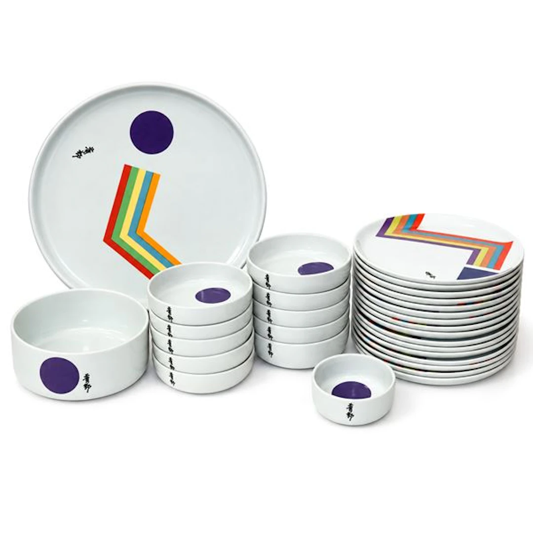 Gruppo di piatti in ceramica bianca con disegno geometrico policromo