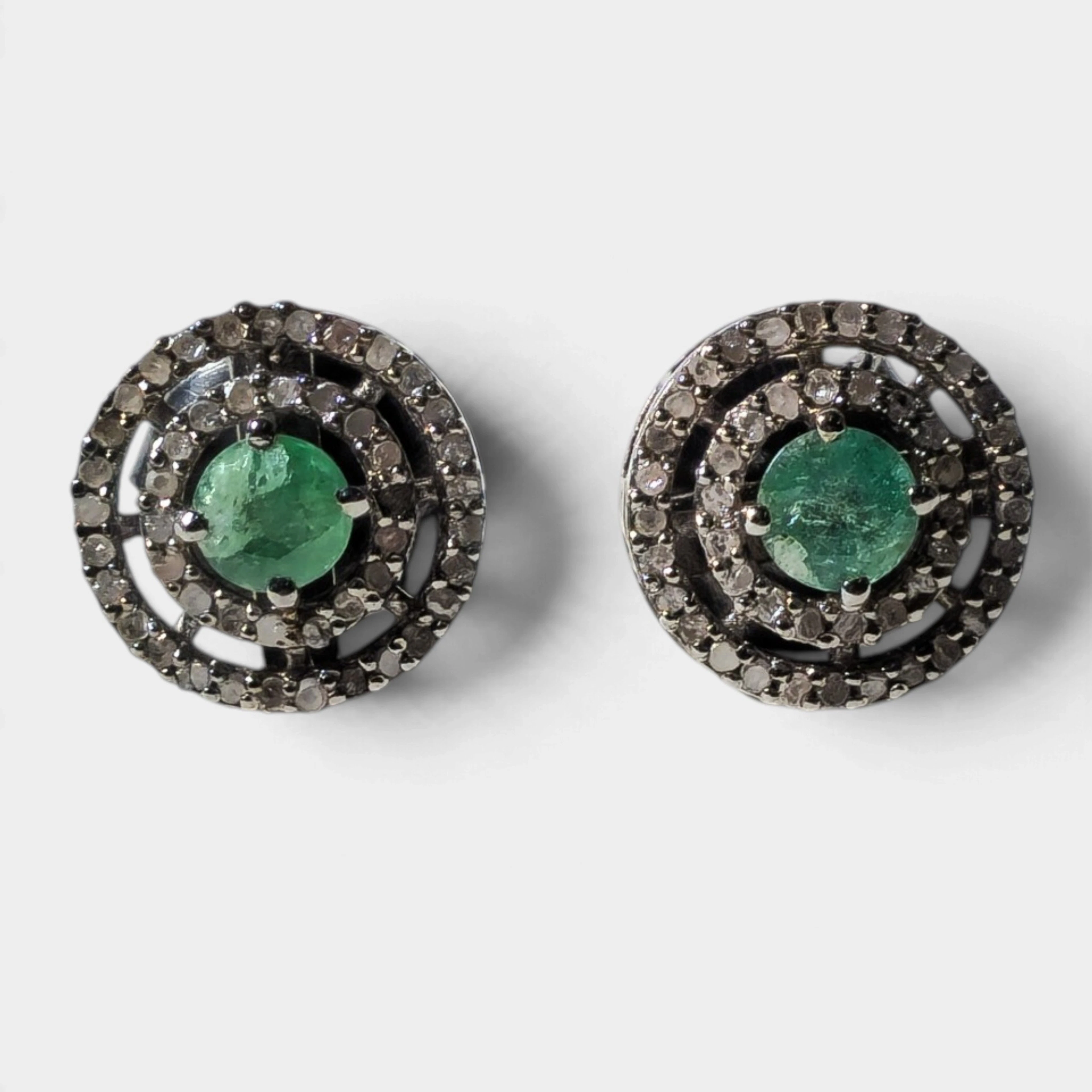 Pendientes en plata con baño de rutenio, esmeraldas y orla de diamantes.