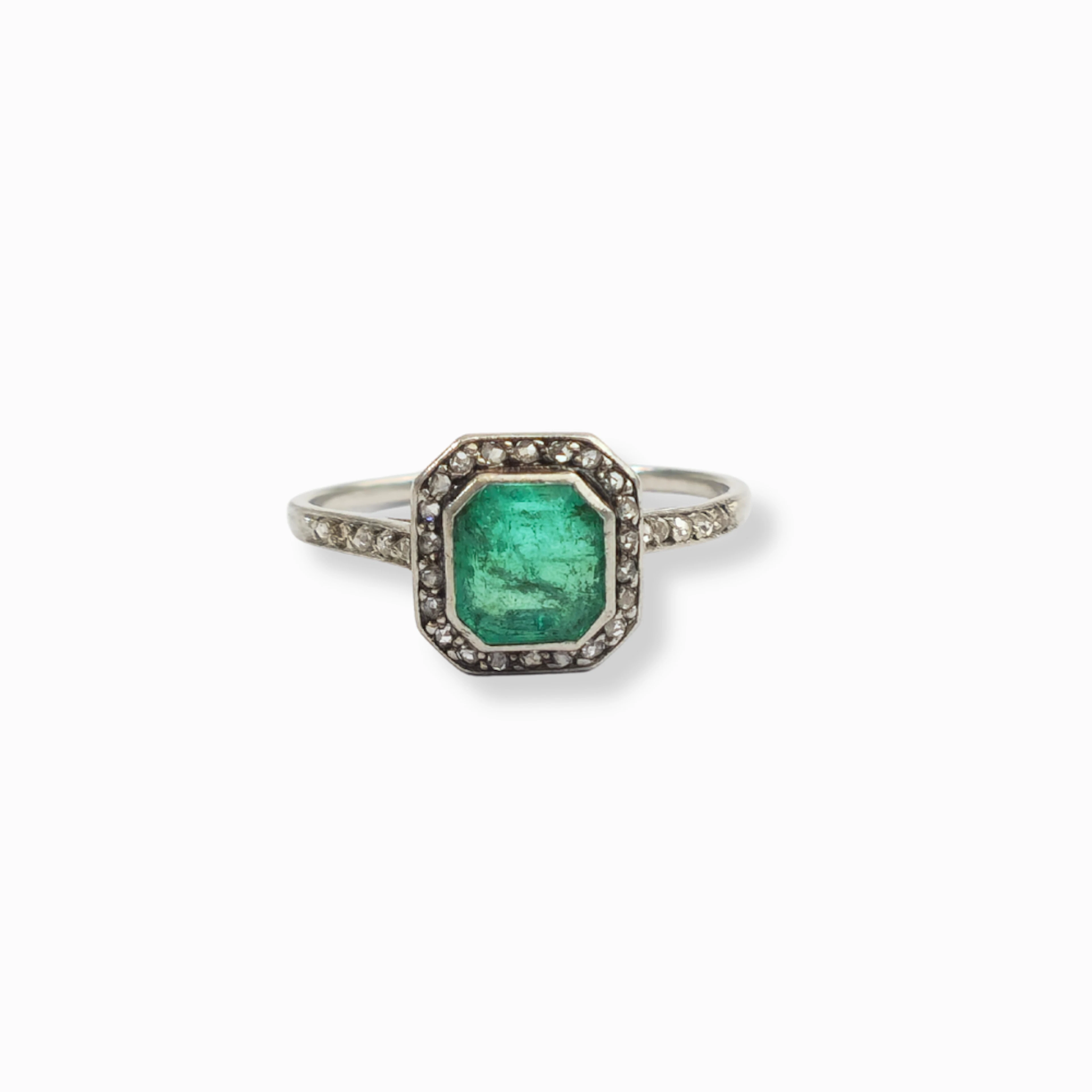 Anillo en oro y platino con esmeralda y orla de diamantes.