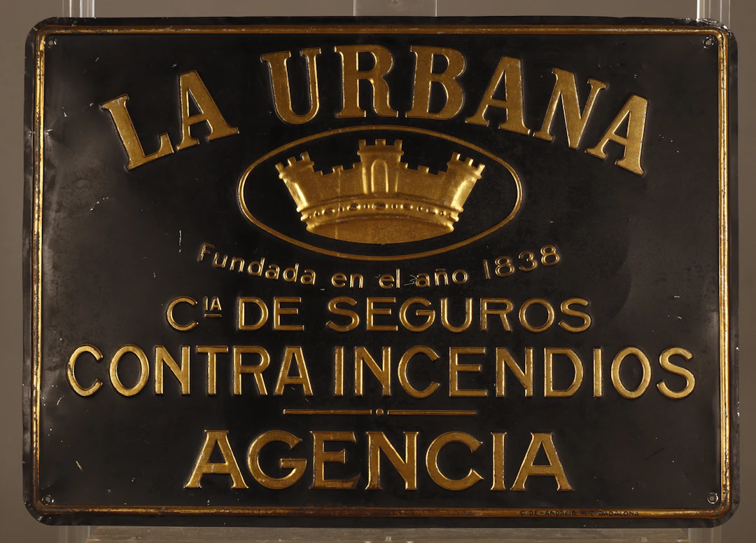 La Urbana, placa publicitaria en hojalata estampada y pintada.