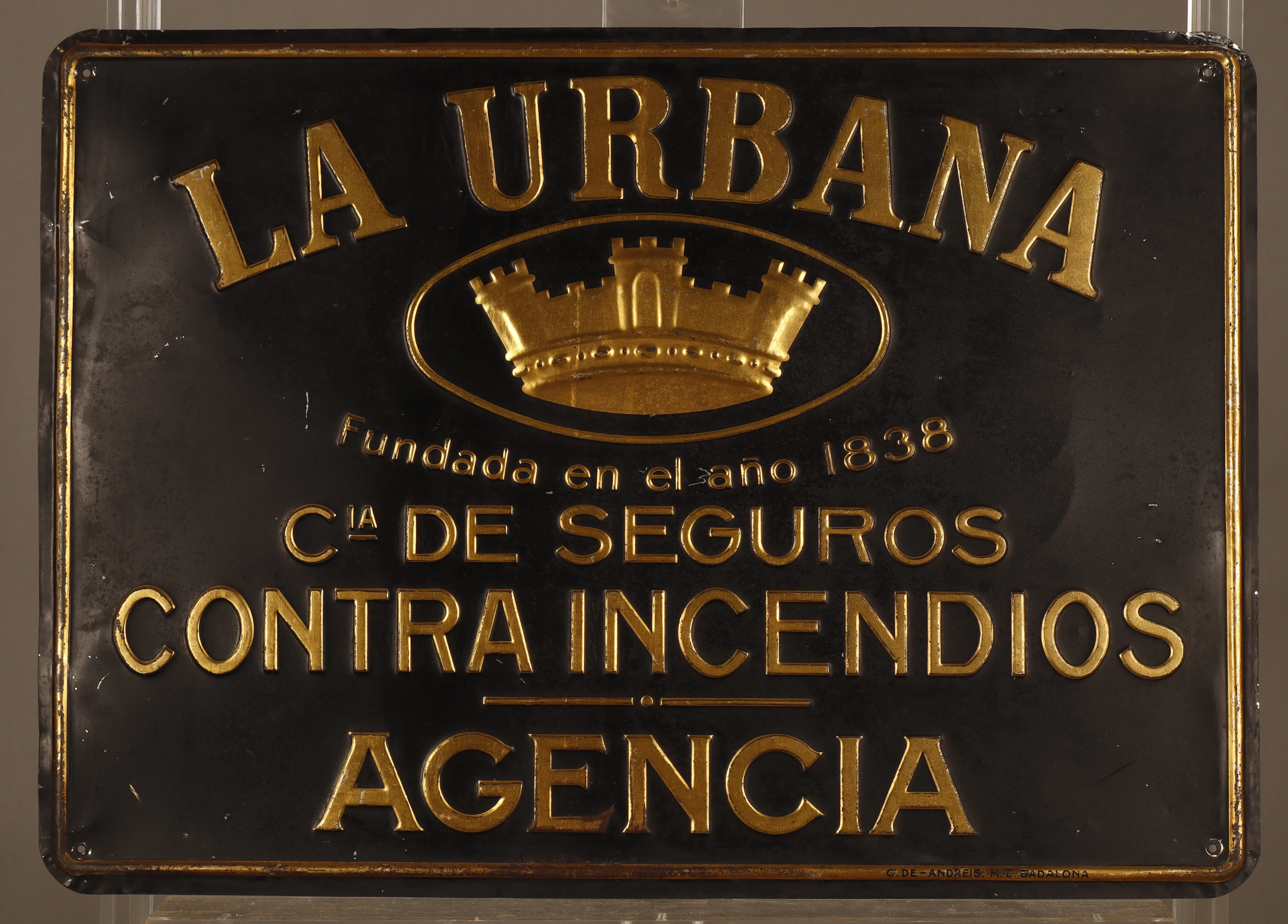 La Urbana, placa publicitaria en hojalata estampada y pintada.