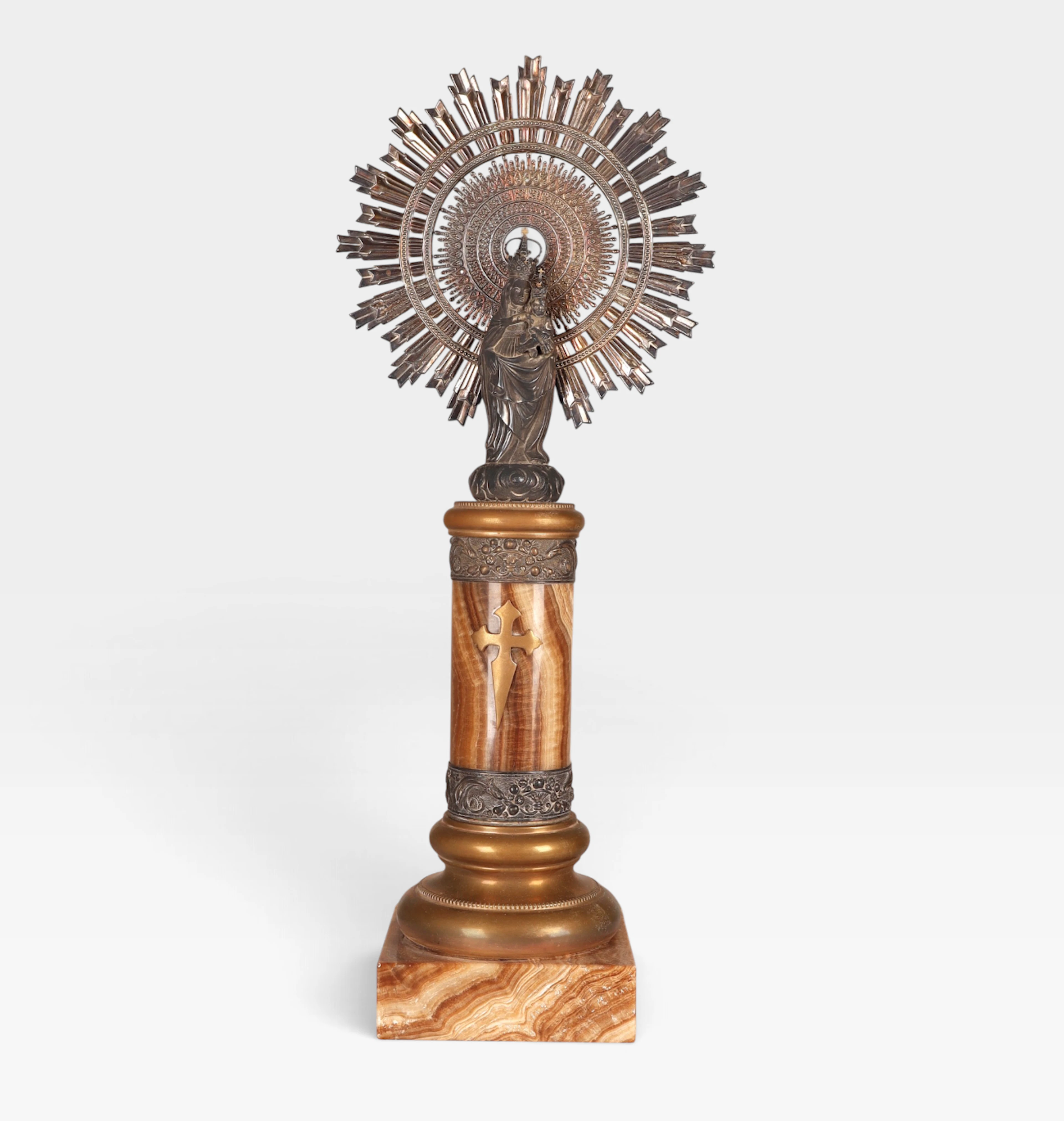 Virgen del Pilar en plata con base en ónice y latón, del siglo XX.