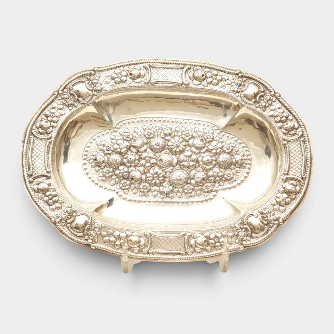 Bandeja ovalada en plata española punzonada. Decoración repujada con