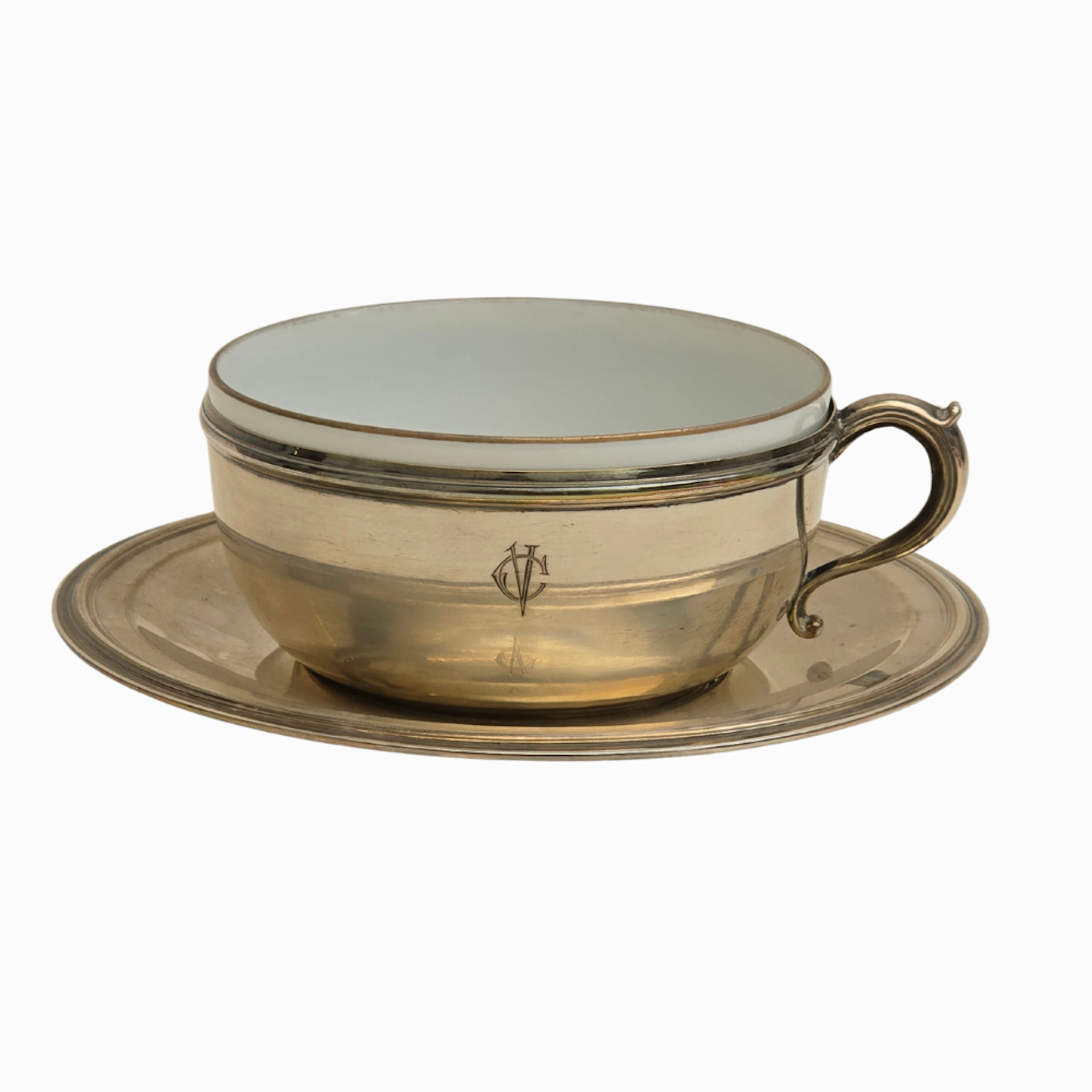 Taza y bajoplato en plata punzonada 916 y porcelana.