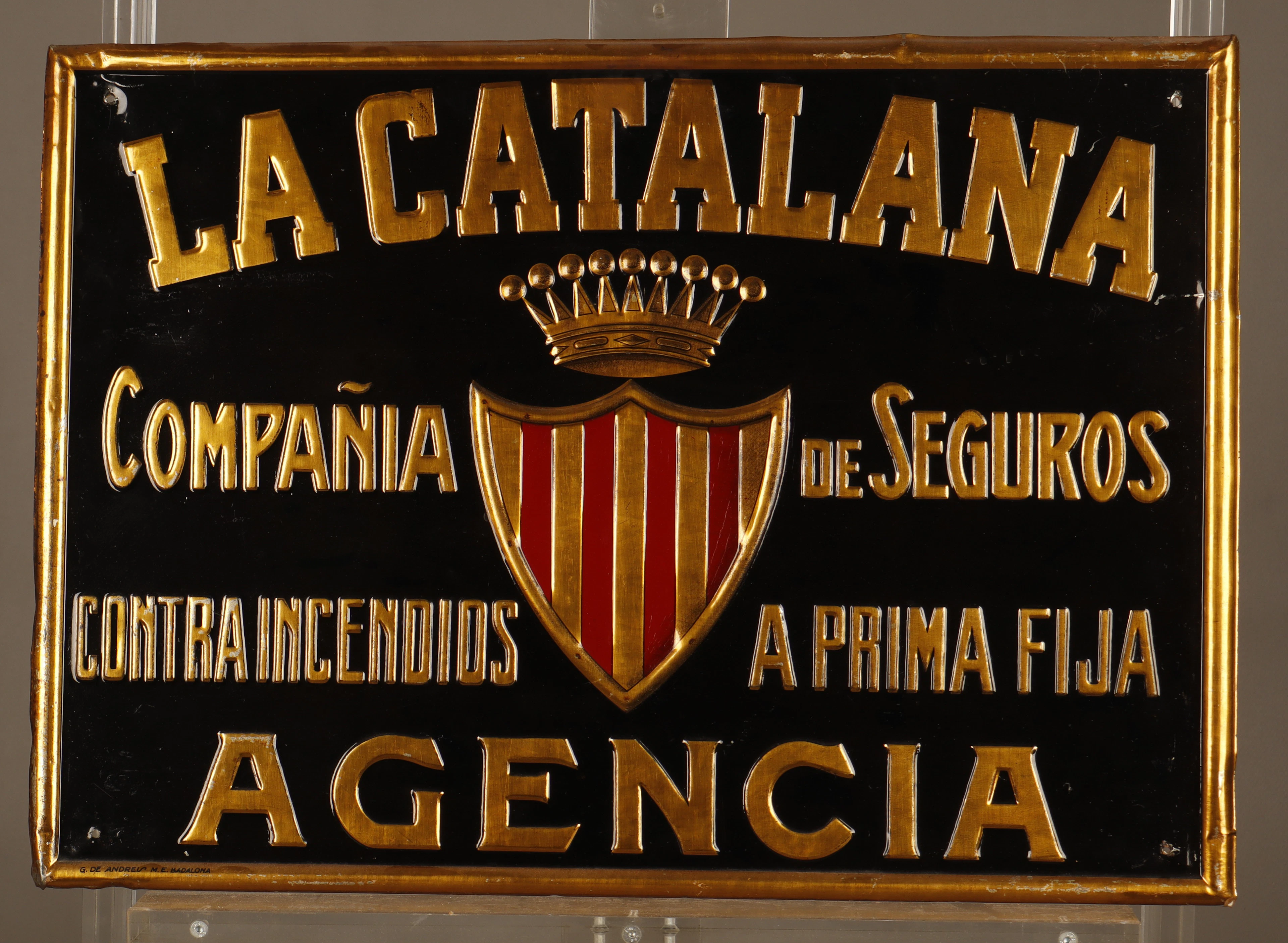 La Catalana, placa publicitaria en hojalata estampada y pintada.