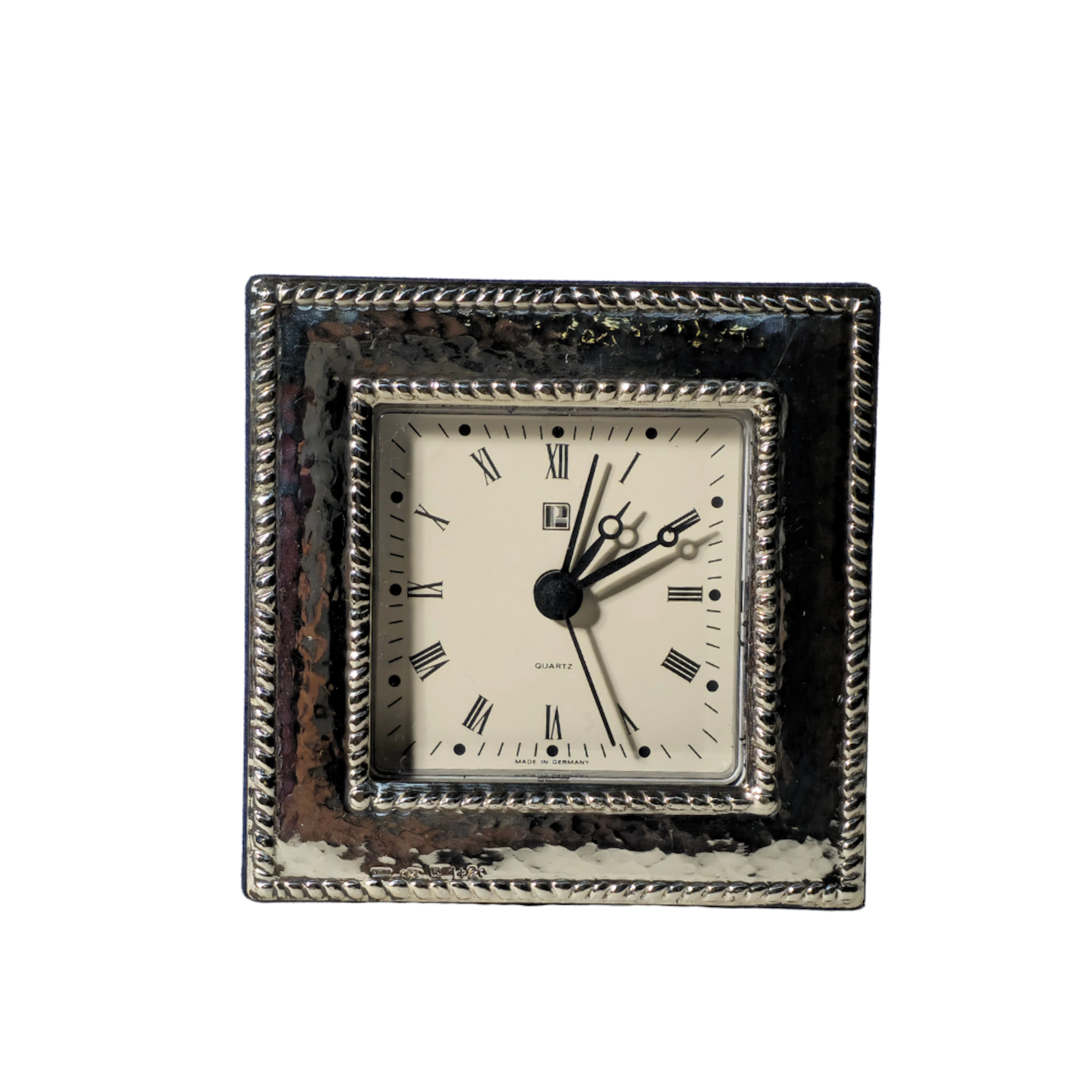 RELOJ DESPERTADOR DE SOBREMESA CON MARCO DE PLATA MARTELÉ Y CENEFA TRENZADA.