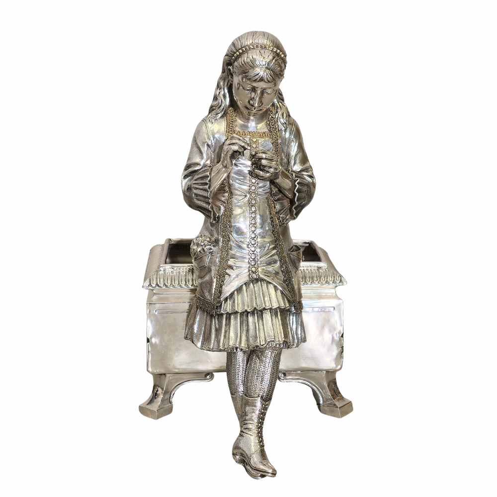 Jardinera con figura femenina sedente en plata.