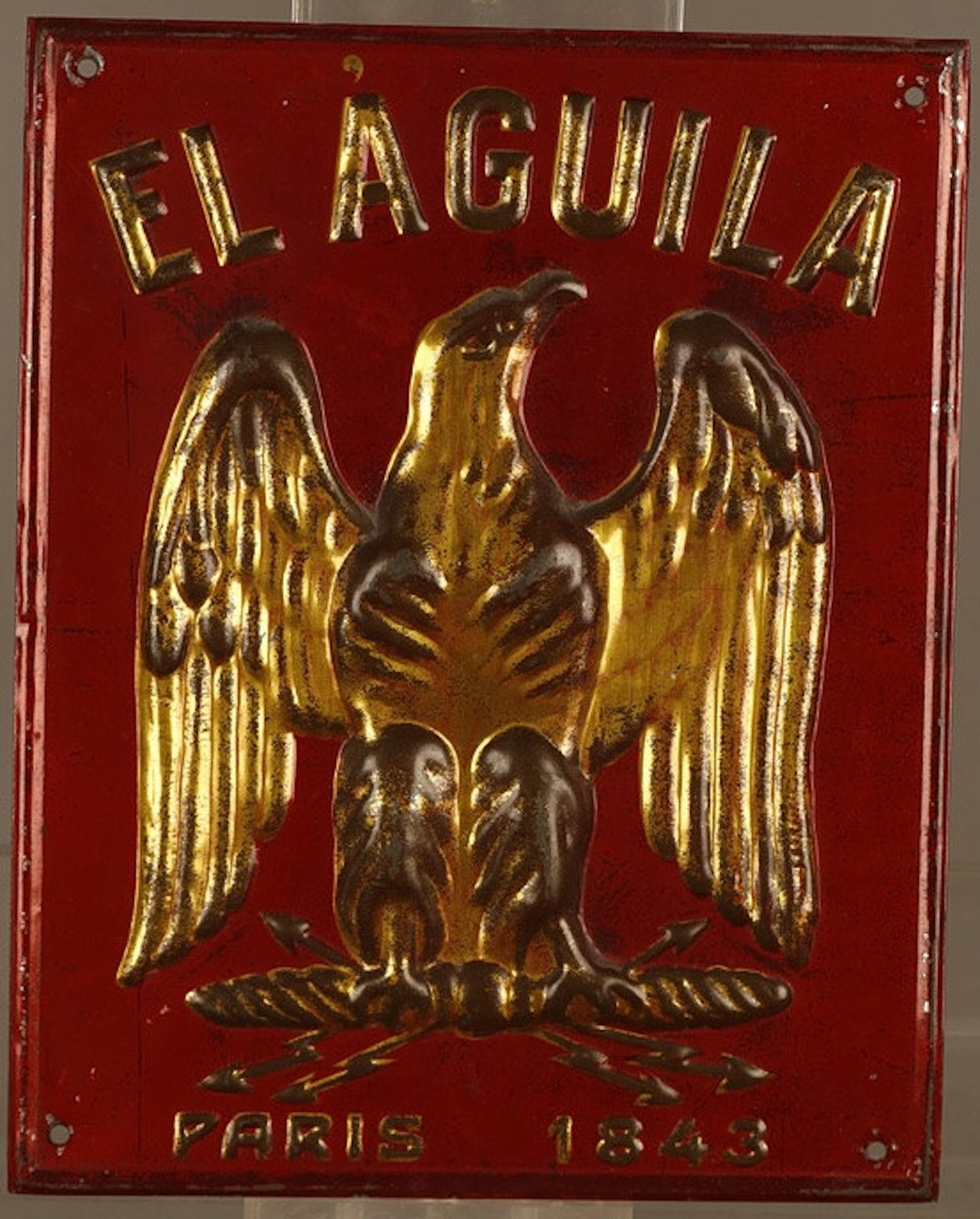 El Aguila, placa publicitaria en hojalata estampada y pintada.