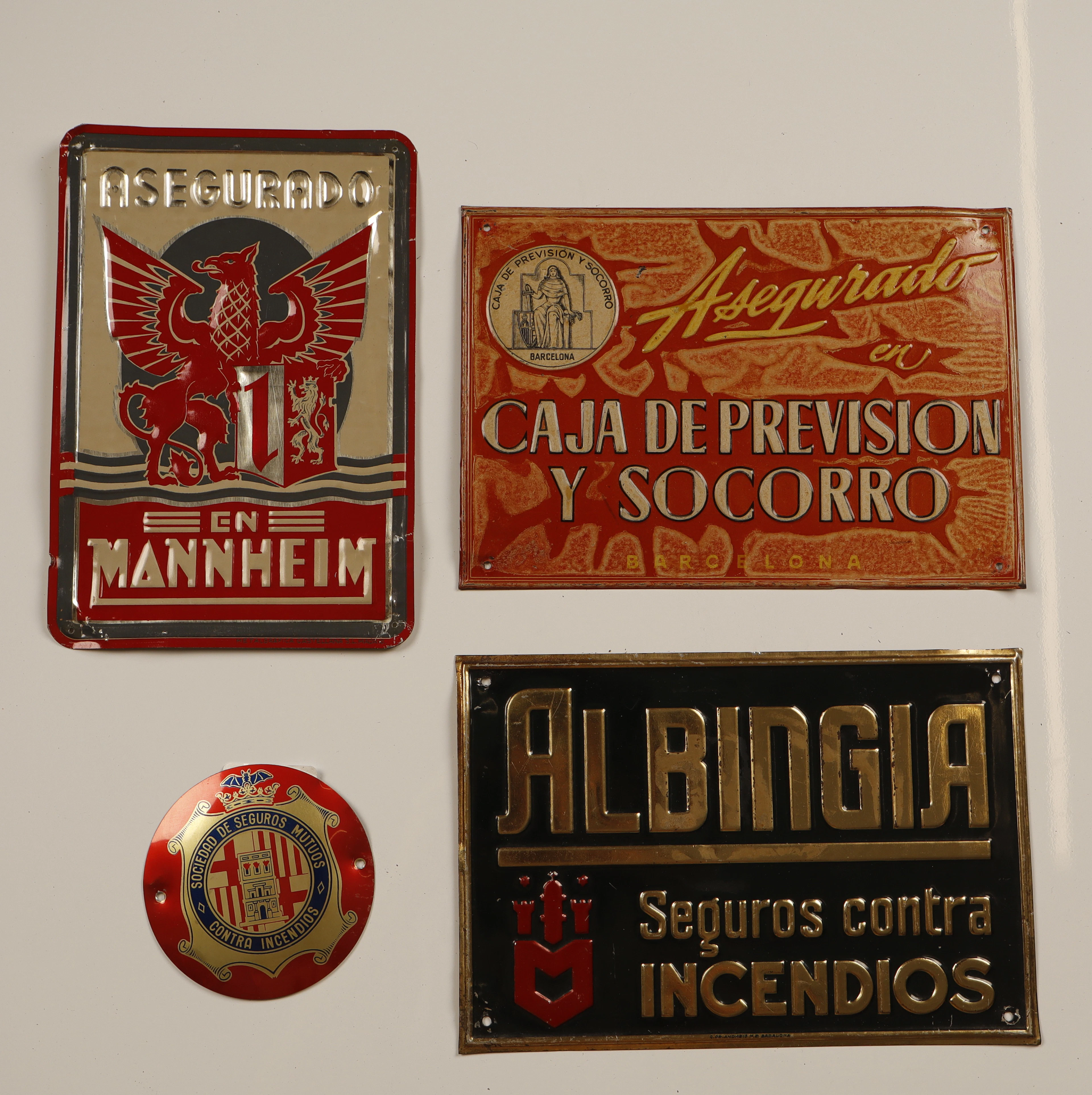 Mannheim y otros, 4 placas publicitarias en hojalata estampada y pintada.