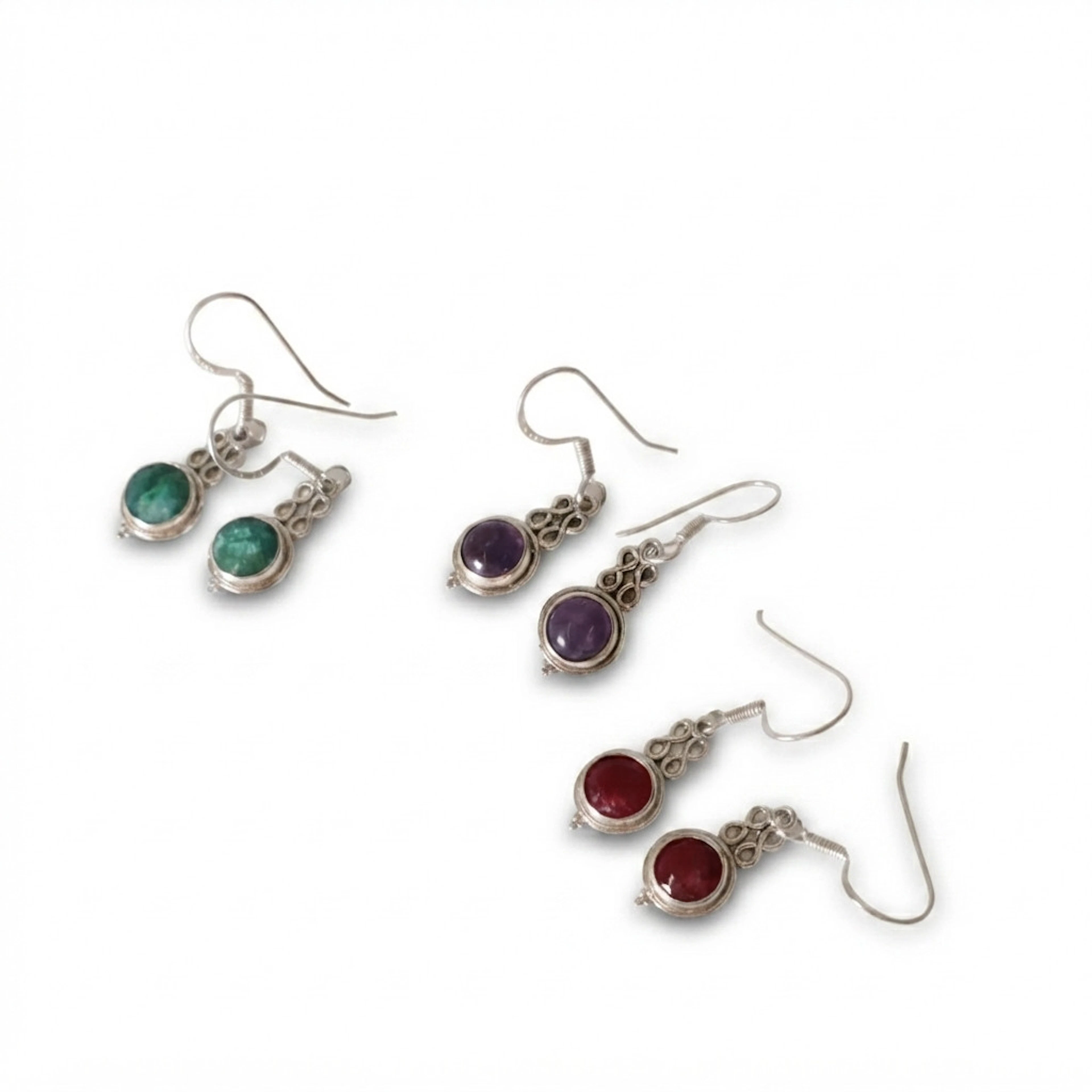 Tres pares de pendientes en plata con amatista con raíz de rubí y esmeralda.