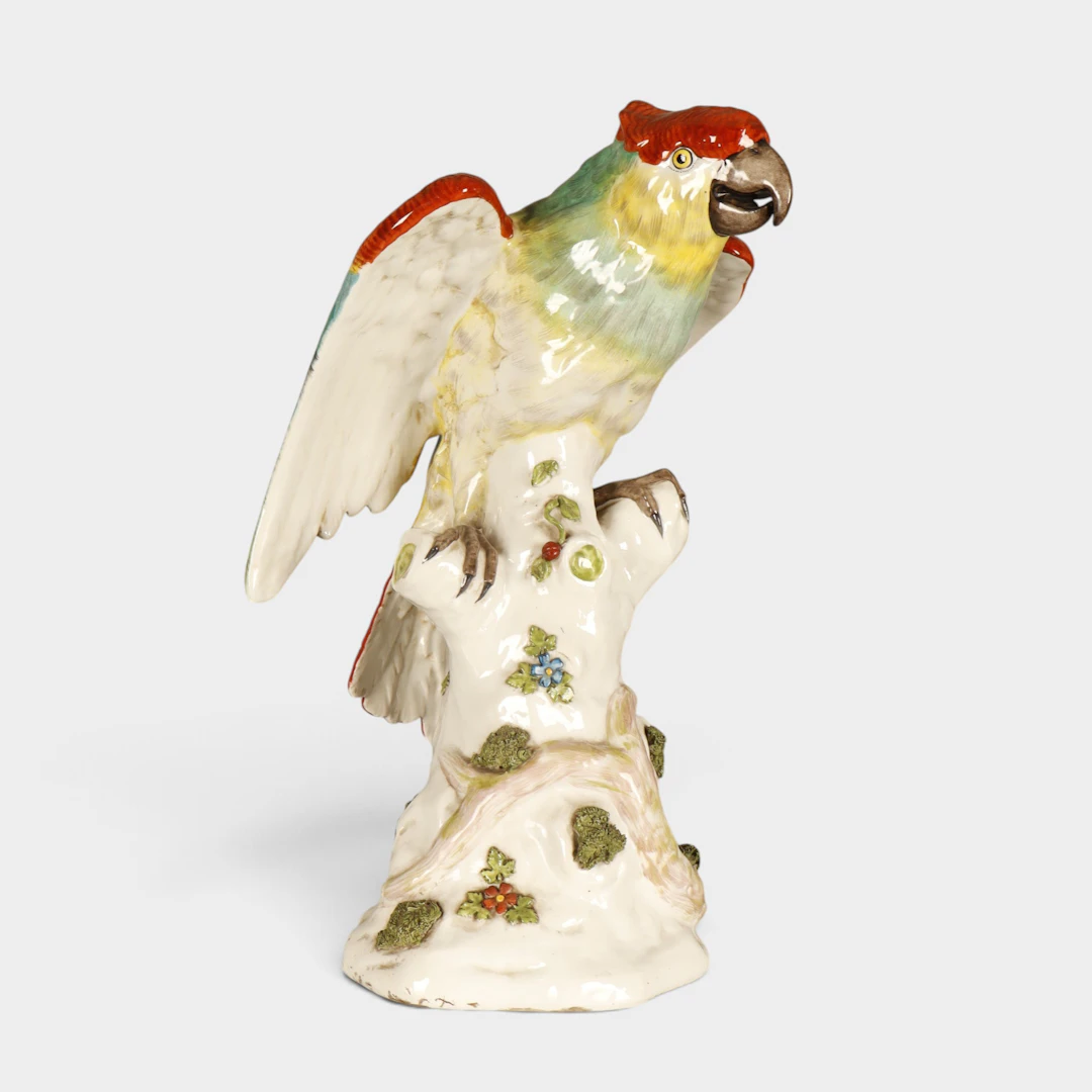 Loro en cerámica esmaltada según modelos de Meissen, de mediados del siglo XX.