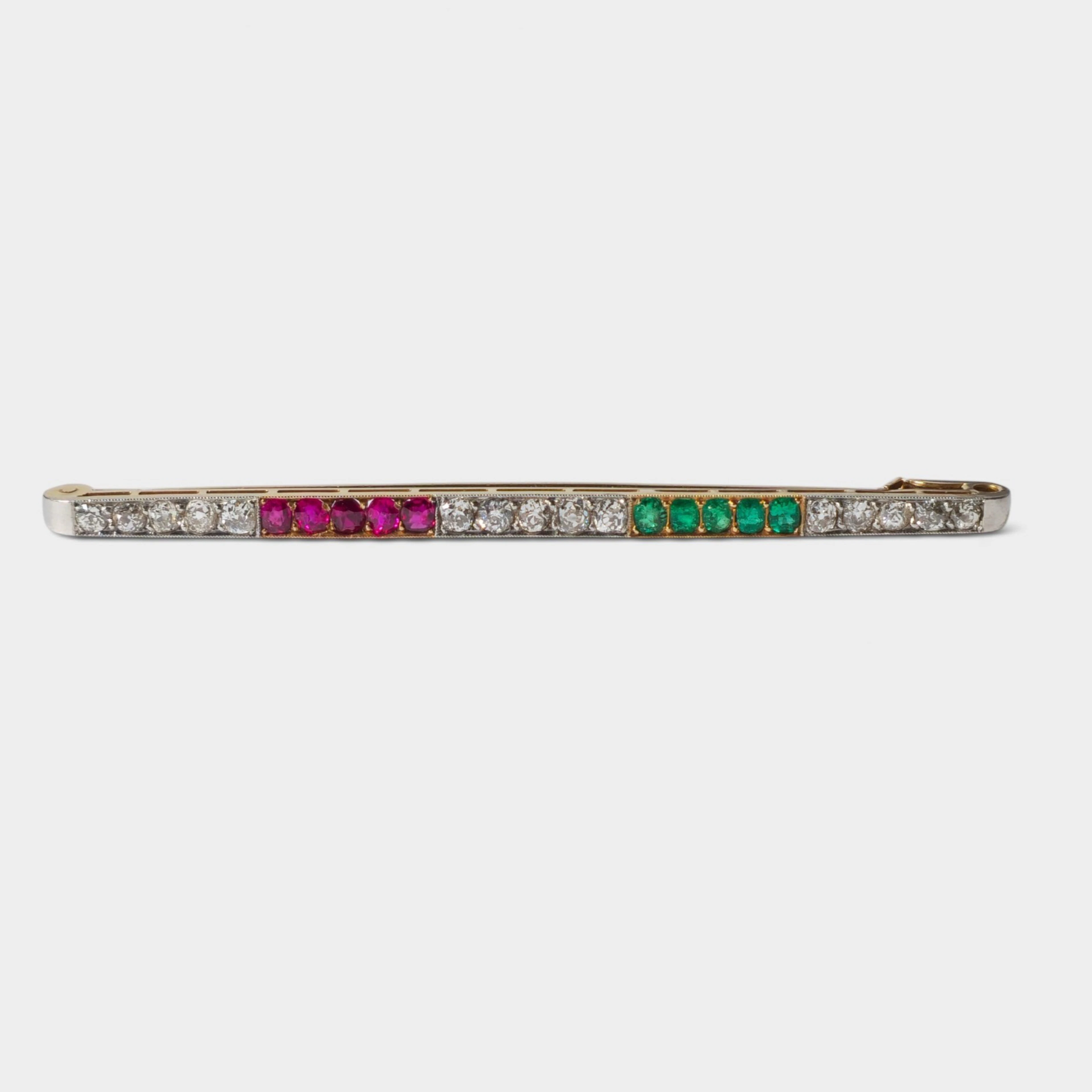 Broche aguja en oro de 18K con diamantes, rubíes y esmeraldas.