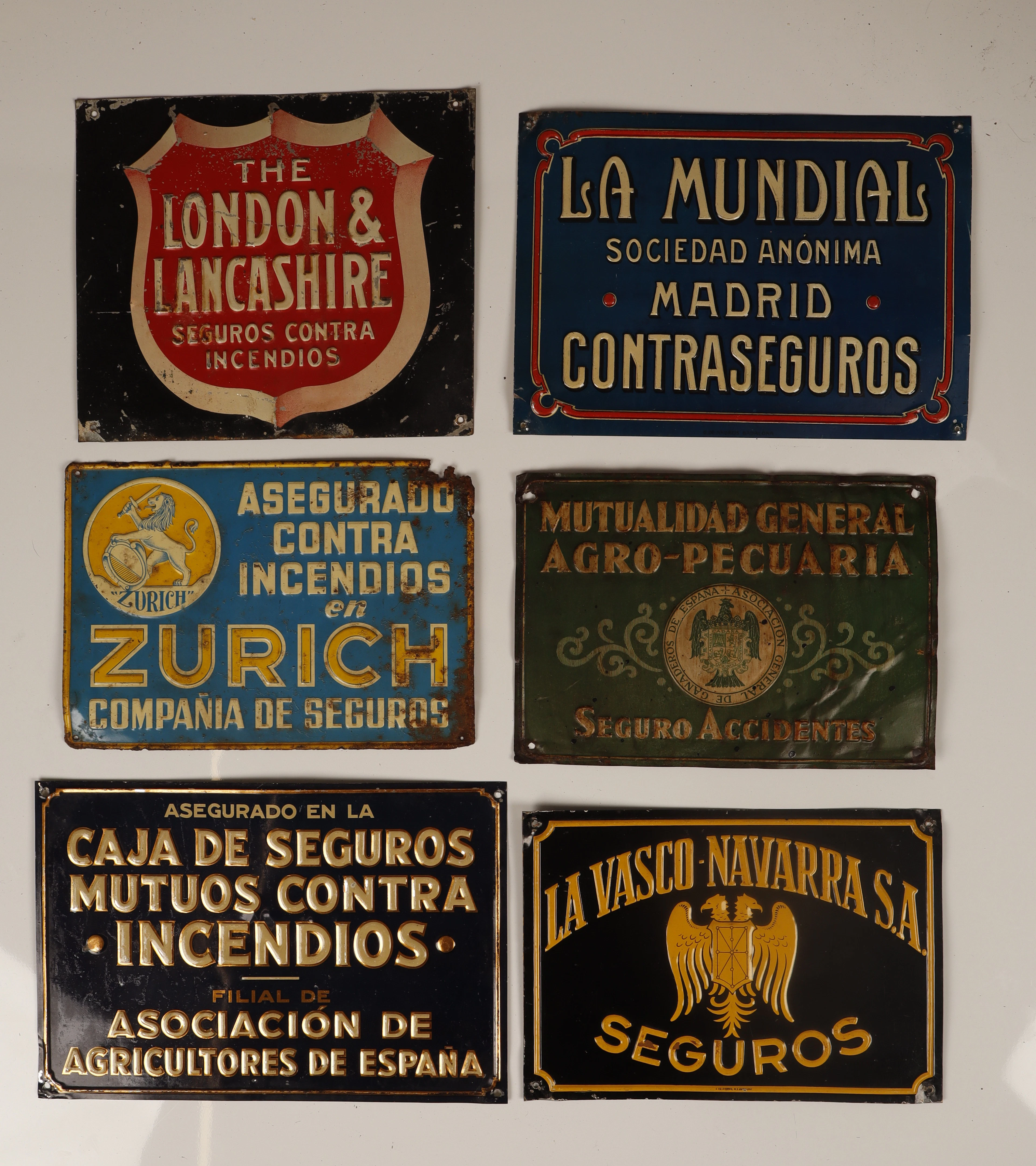 La Mundial y otras. 6 placas publicitarias en hojalata estampada y pintada.