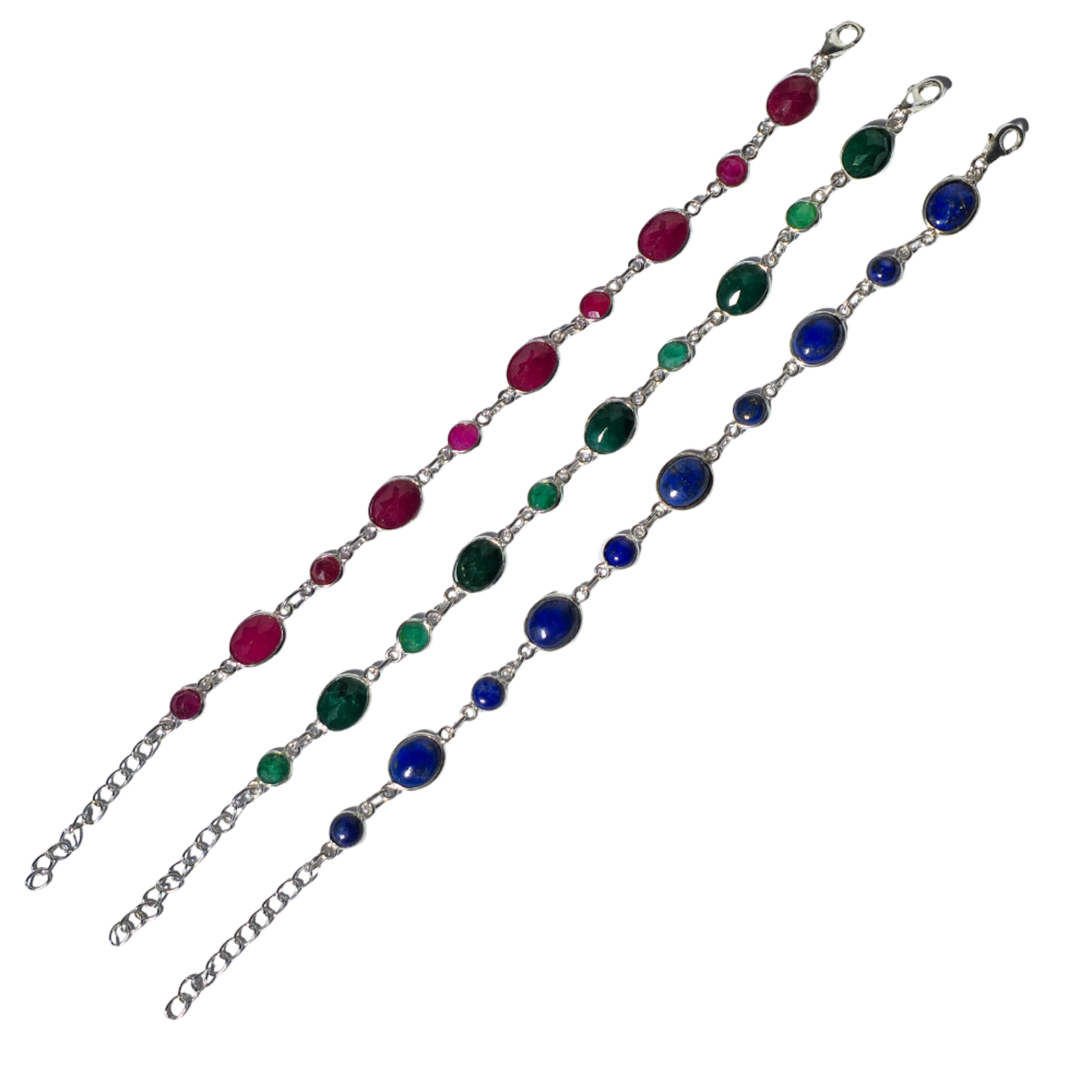 TRES PULSERAS EN PLATA Y LAPISLÁZULI, RAÍZ DE ESMERALDA Y RUBÍ.