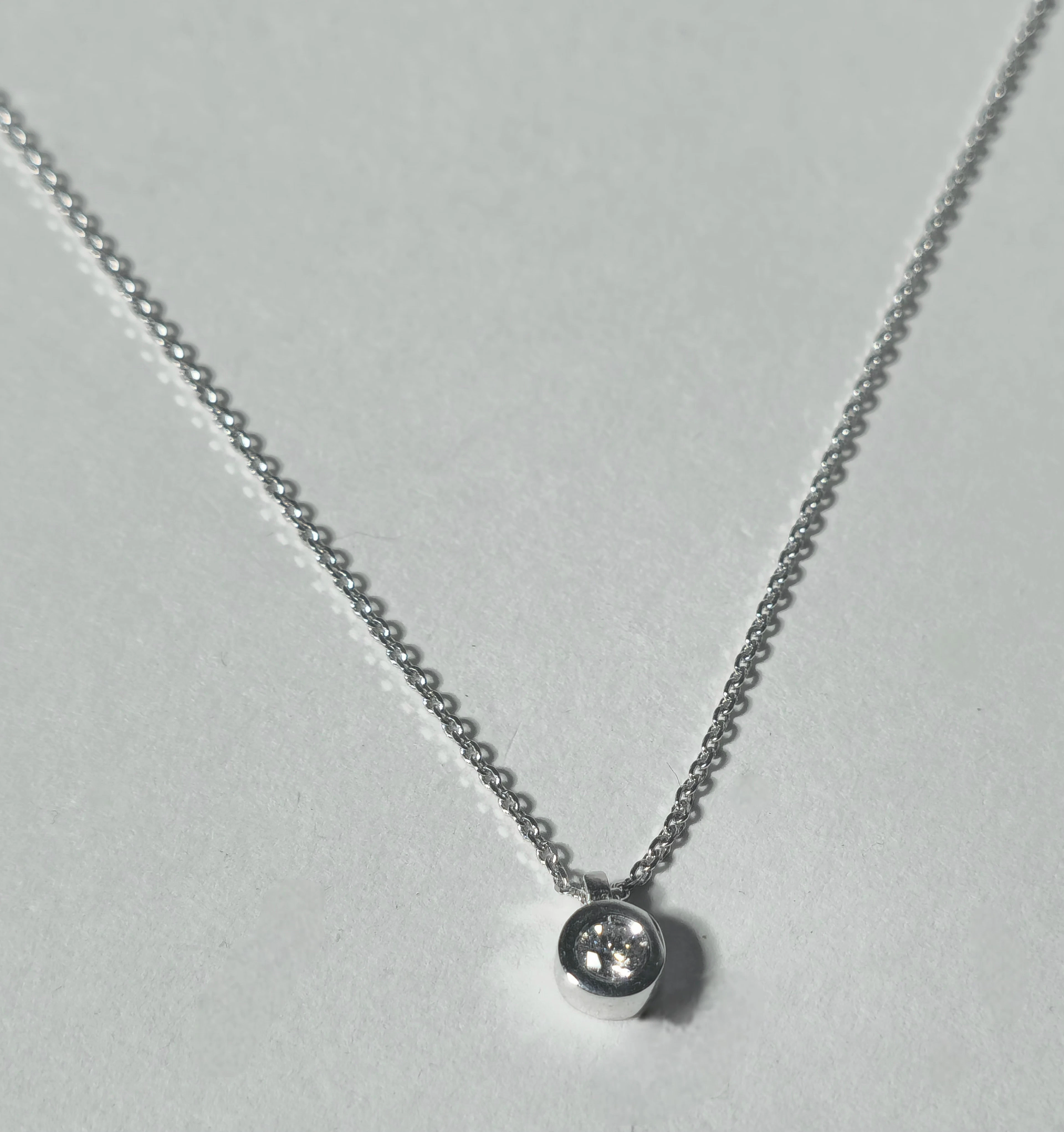 COLGANTE DE DIAMANTE EN CHATÓN 0,10 QUILATES CON MONTURA Y CADENA EN PLATA.