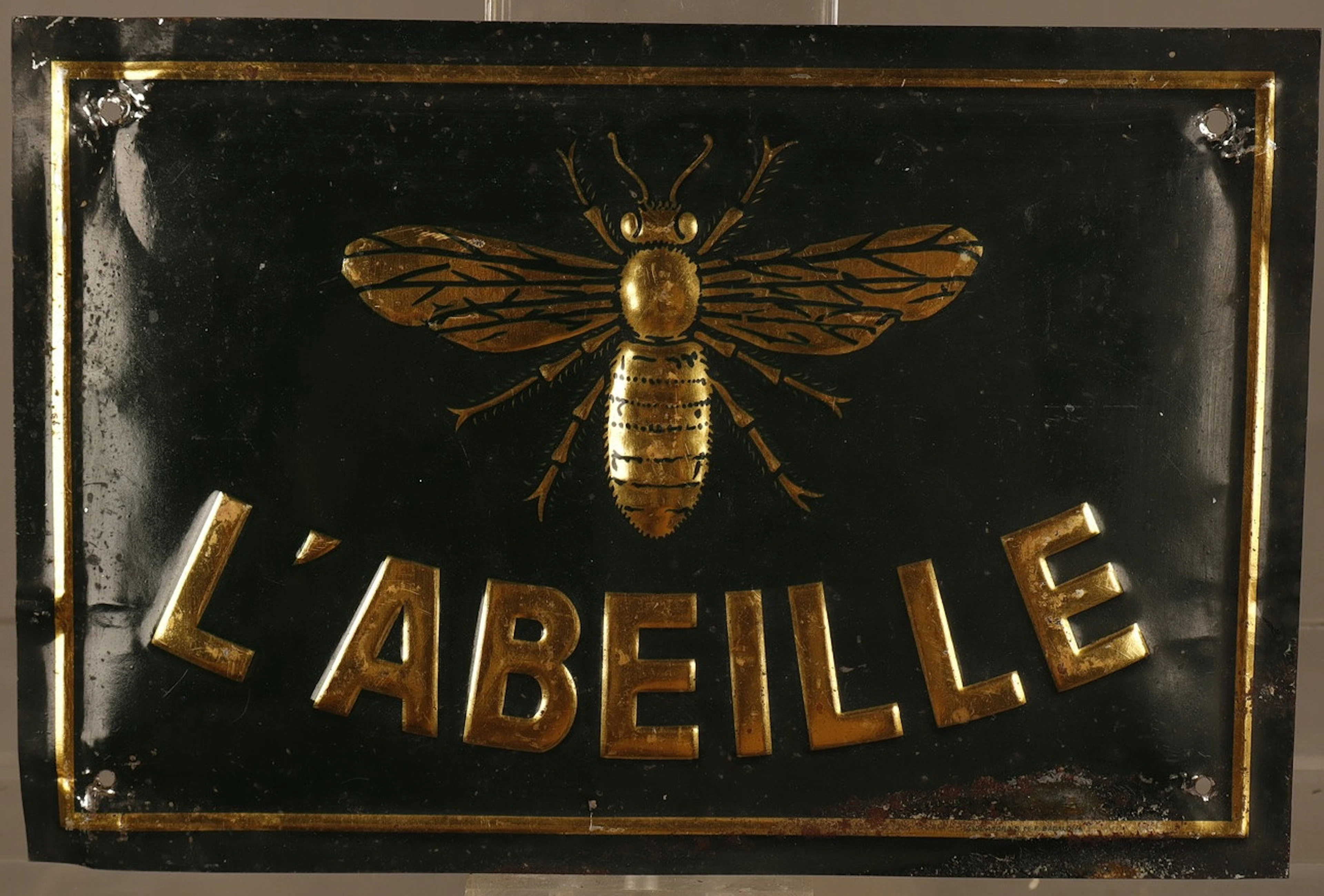 L'Abeille, placa publicitaria en hojalata estampada y pintada.