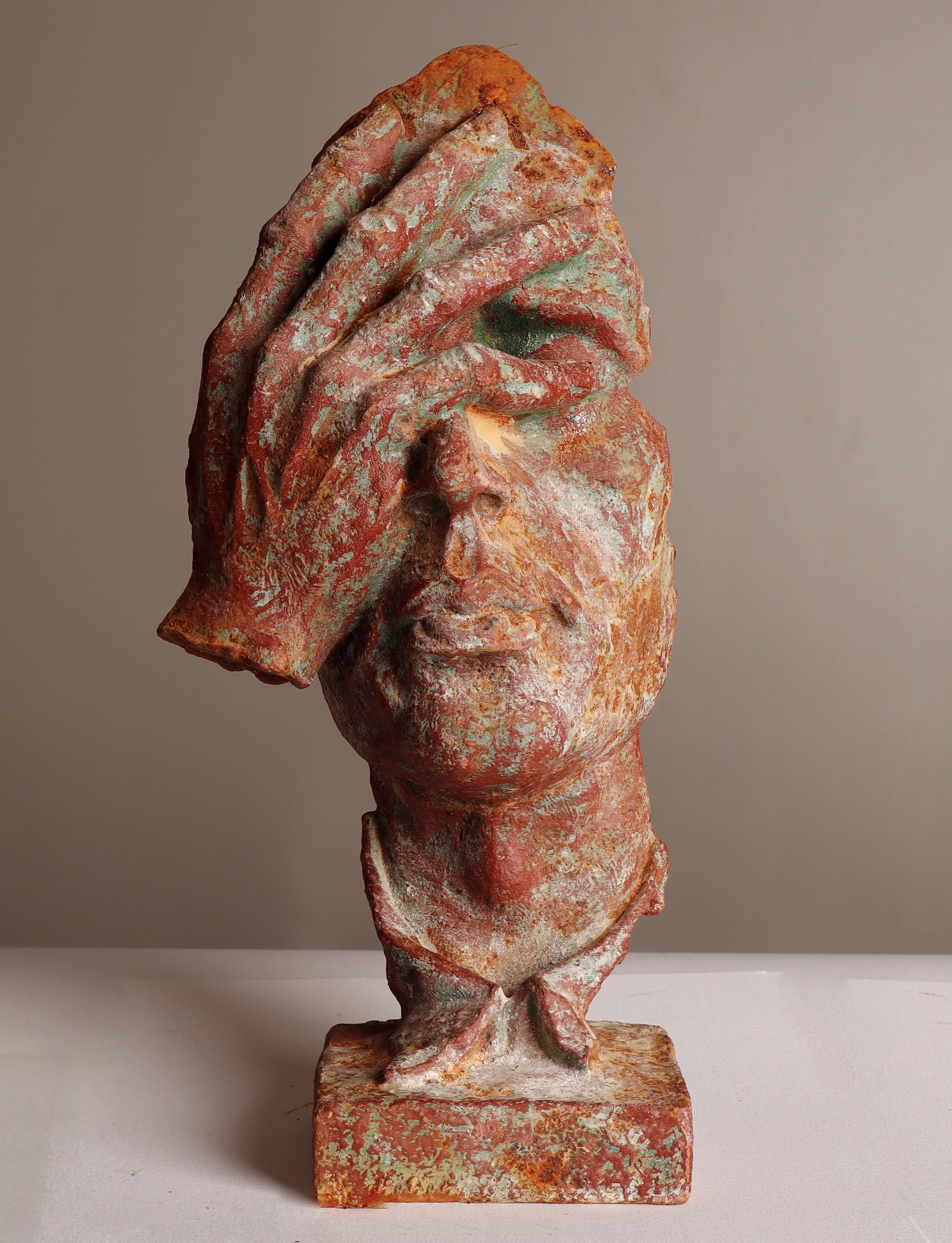 Rostro y mano en altorrelieve, escultura de jardín en hierro.