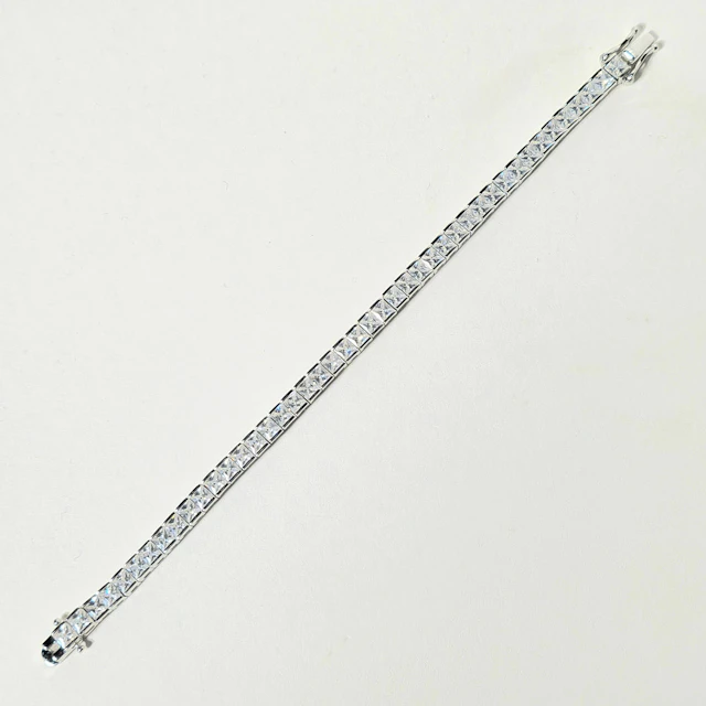 Pulsera riviere en plata rodiada con circonitas talla princesa.