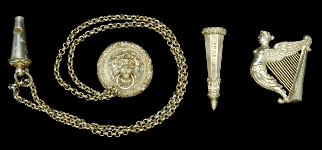 An Officer’s Whistle, Guard and Chains, with a silver Irish Badge.