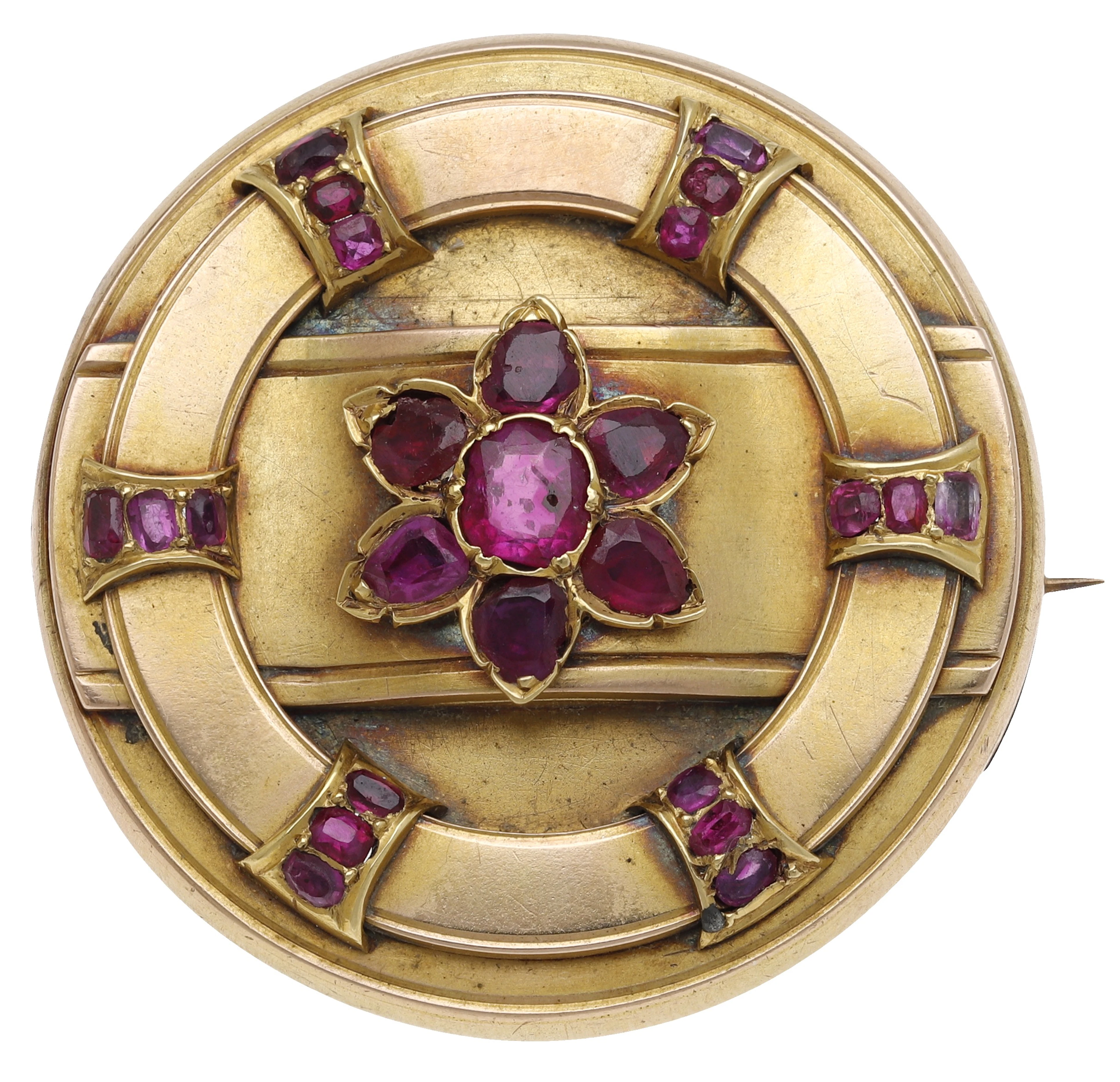 A gold and ruby circular brooch, the roundel with applied strapwork