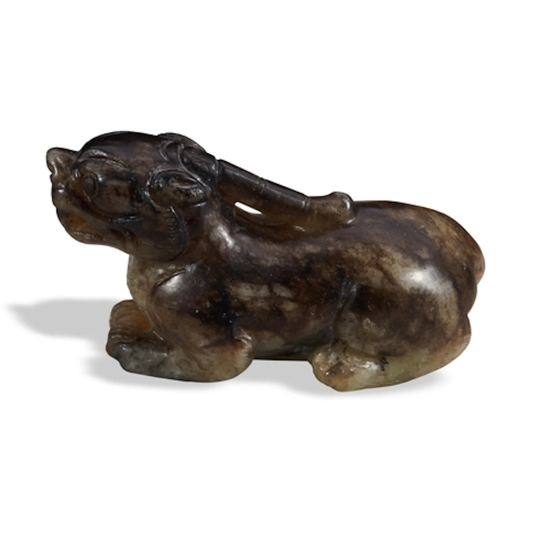 A MOTTLED BROWN JADE FIGURED OF A MYTHICAL BEAST 19TH / 20T...