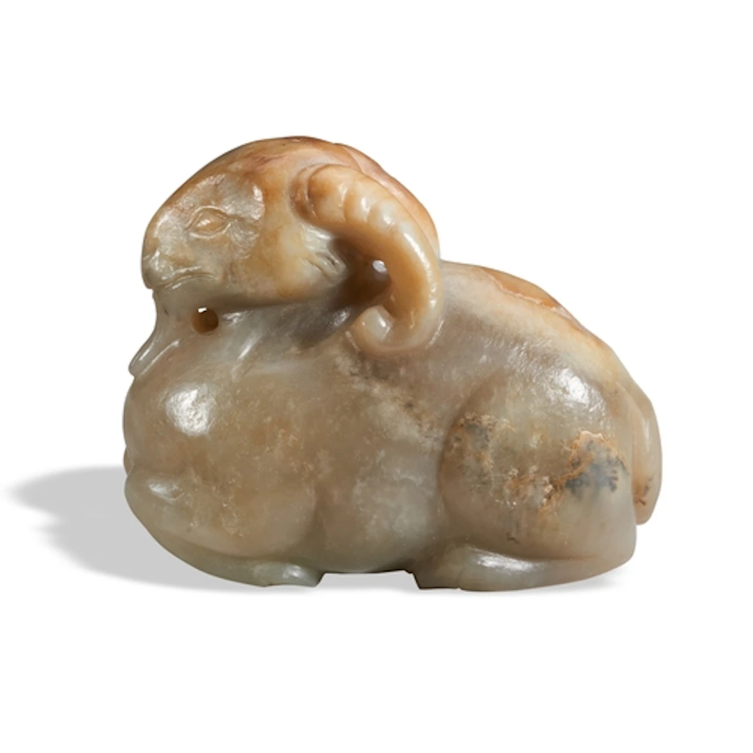 A CELADON AND RUSSET JADE FIGURE OF A RAM QING DYNASTY, 19T...