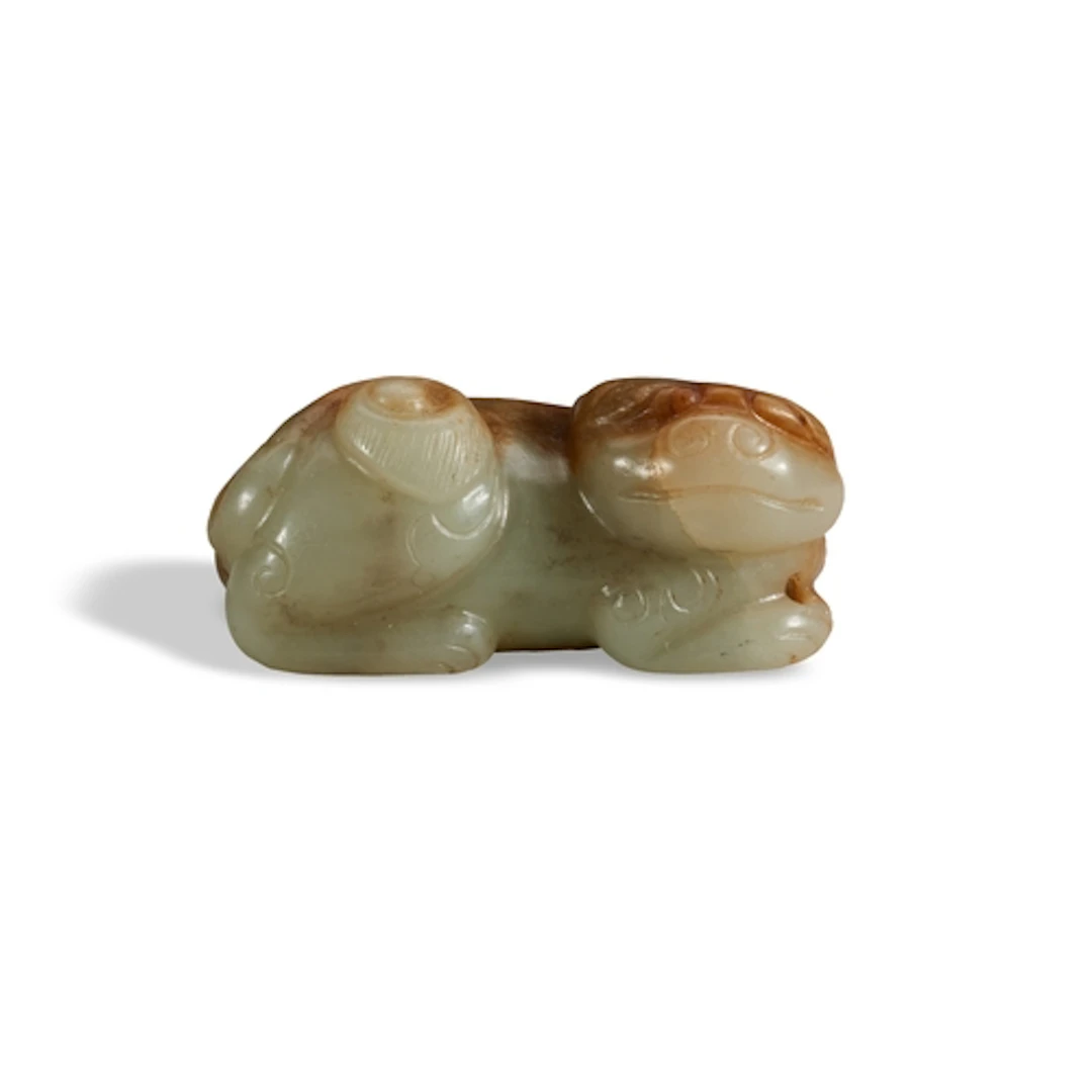 A MOTTLED BROWN CELADON LION MING DYNASTY (1368-1644) 白褐玉狮 明...