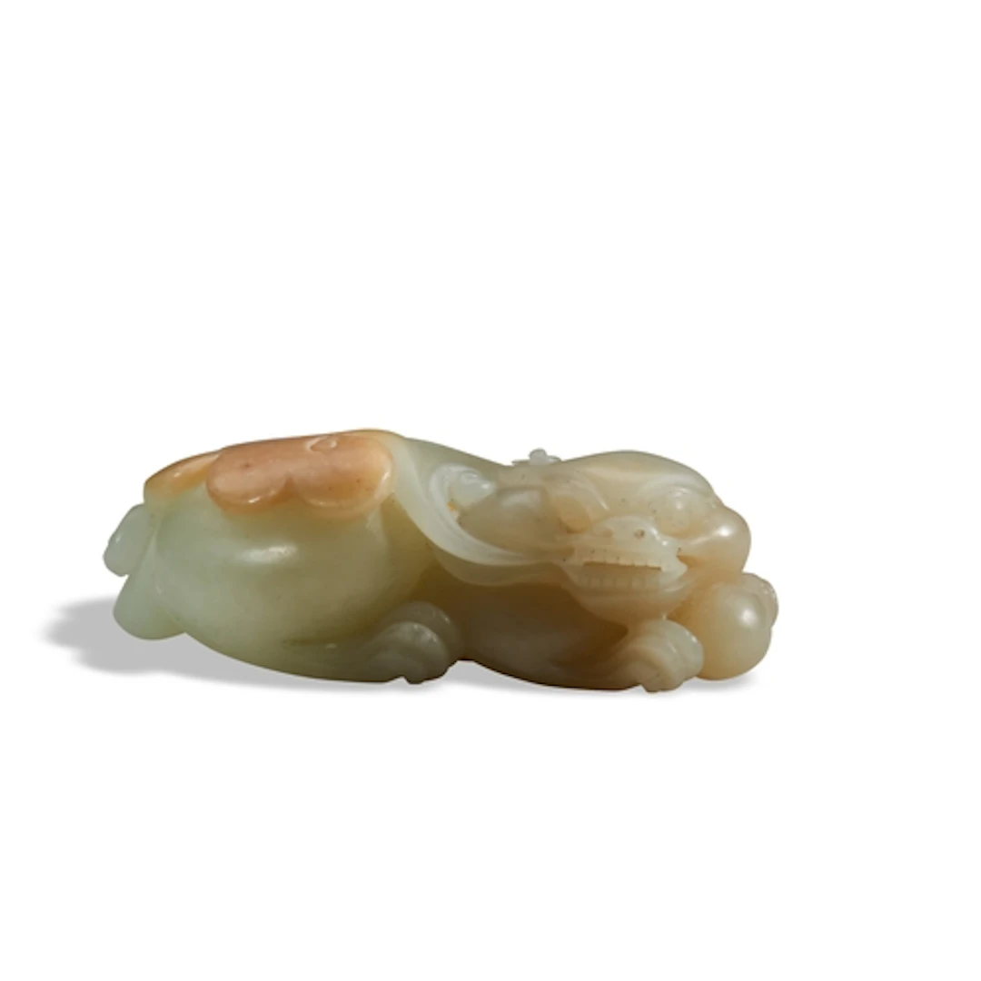 A CELADON AND RUSSET JADE CARVING OF A MYTHICAL BEAST 20TH C...