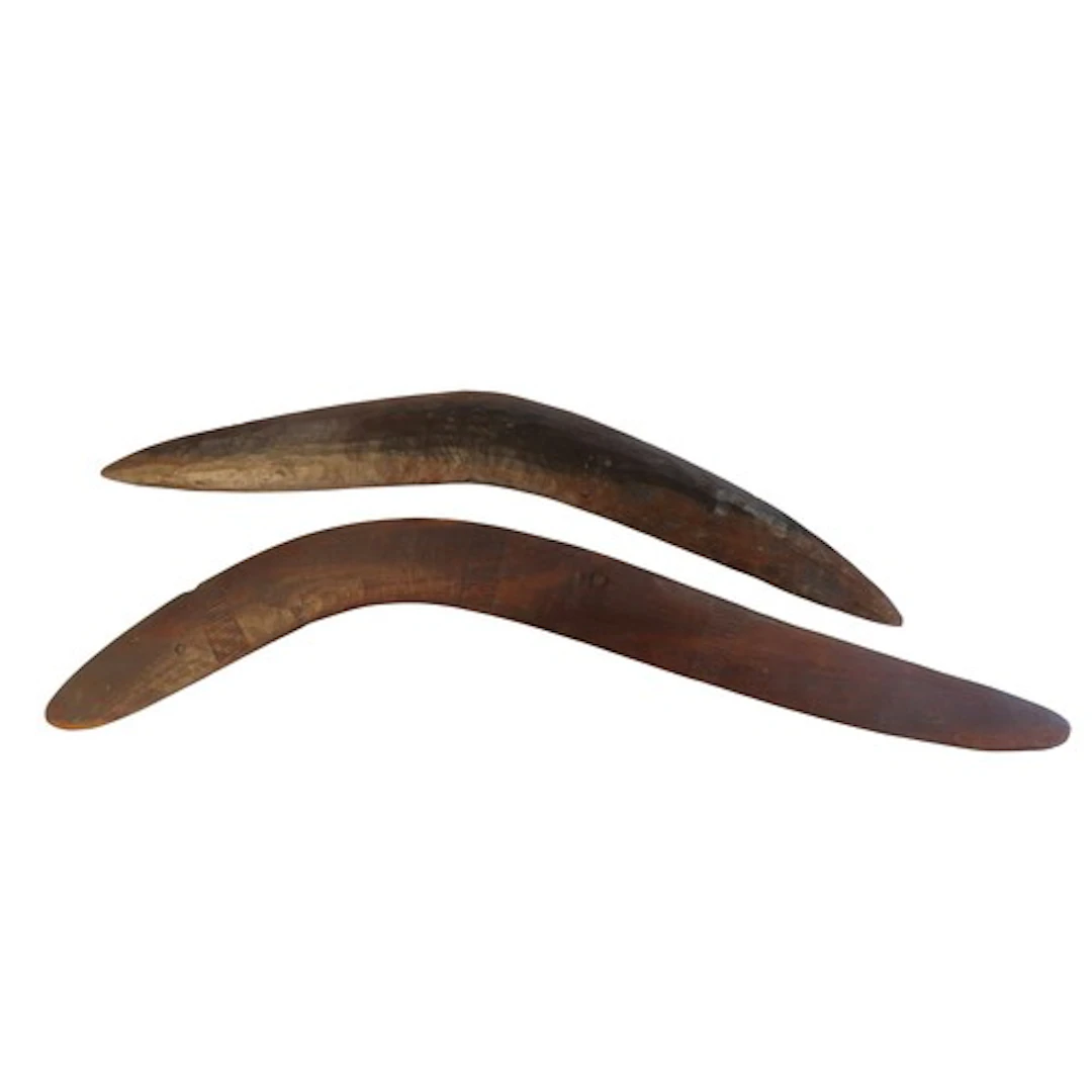 AN ABORIGINAL BOOMERANG with flaked chip carved finish and a...
