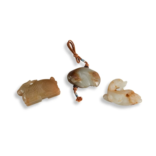 TWO RUSSET JADE 'MYTHICAL-BEAST' PENDANTS QING DYNASTY OR LA...