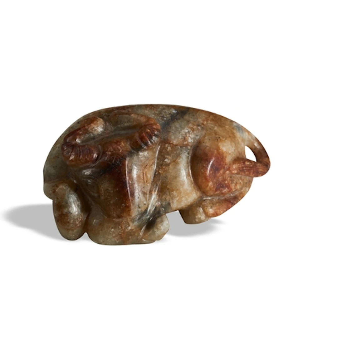 A MOTTLED BROWN JADE FIGURE OF A BUFFALO QING DYNASTY, 19TH...