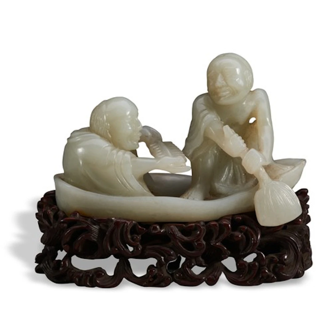 A CELADON JADE FIGURE GROUP OF TWO SCHOLARS ON THE BOAT QING...