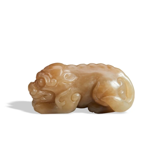 A MOTTLED CARAMEL JADE FIGURE OF A LION 20TH CENTURY 黄褐玉狮 二...