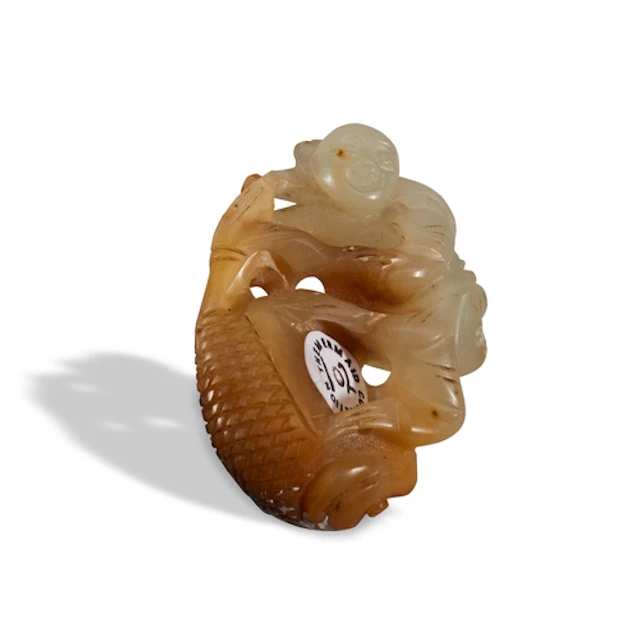 A CELADON AND RUSSET JADE 'BOY AND FISH' GROUP QING DYNASTY,...