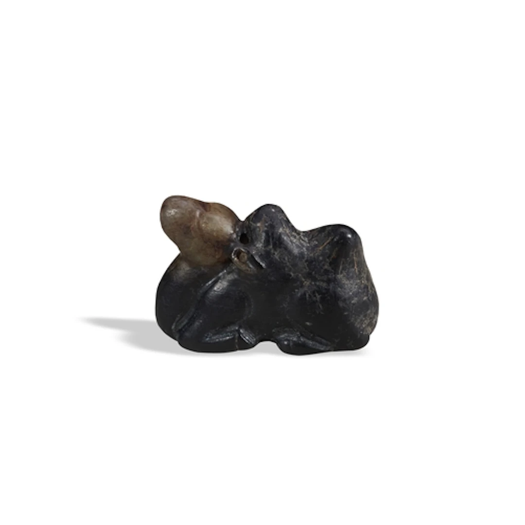 A BLACKISH-BROWN JADE FIGURE OF A CAMEL QING DYNASTY, 19TH C...