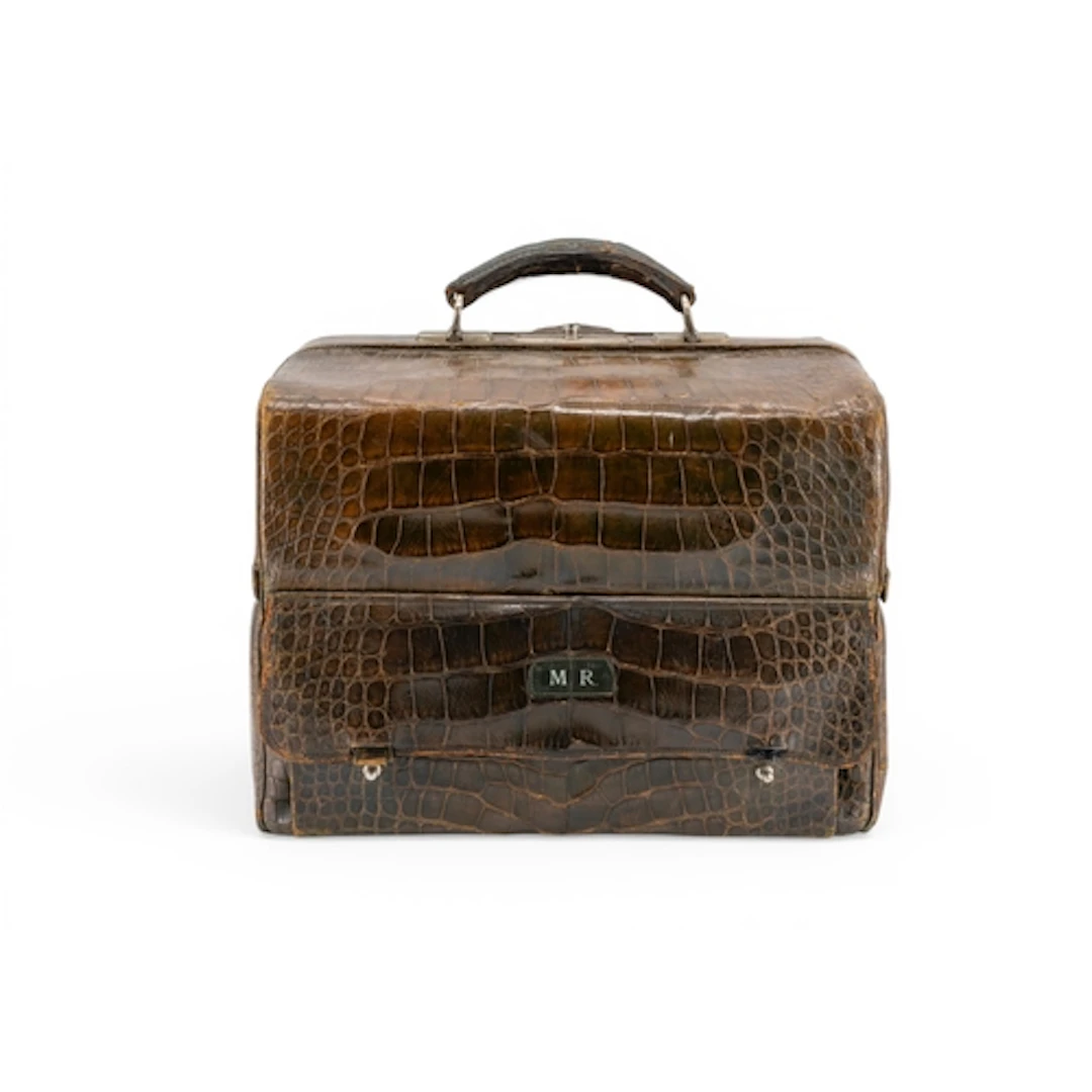 A FAUX CROCODILE TRAVELLING TOILET BAG with green silk-lined...