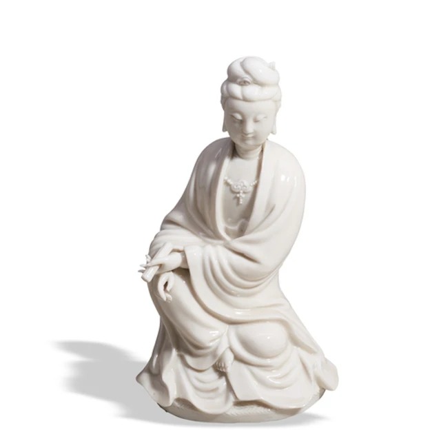 A BLANC DE CHINE SEATED FIGURE OF GUANYIN ON A REED MAT EARL...