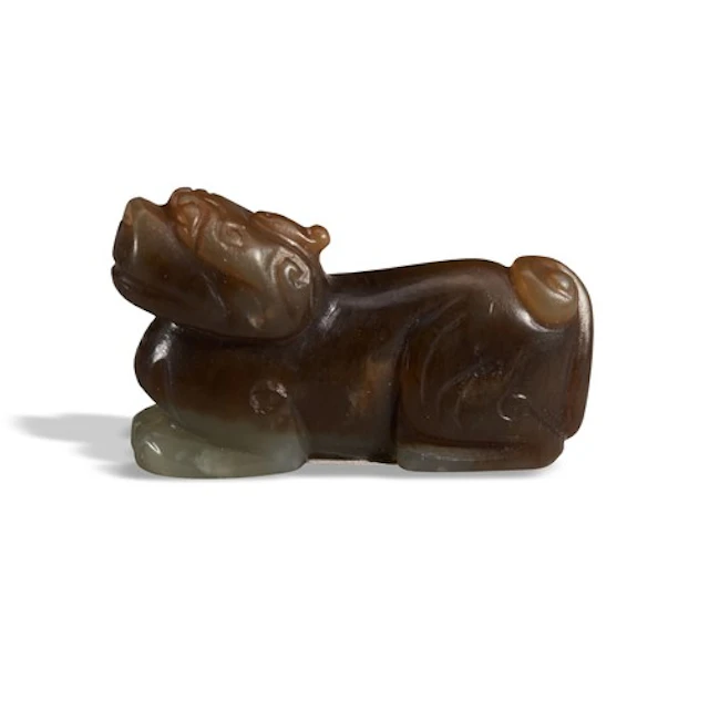 A BLACKISH-BROWN AND WHITE JADE LION MING DYNASTY (1368-1644...